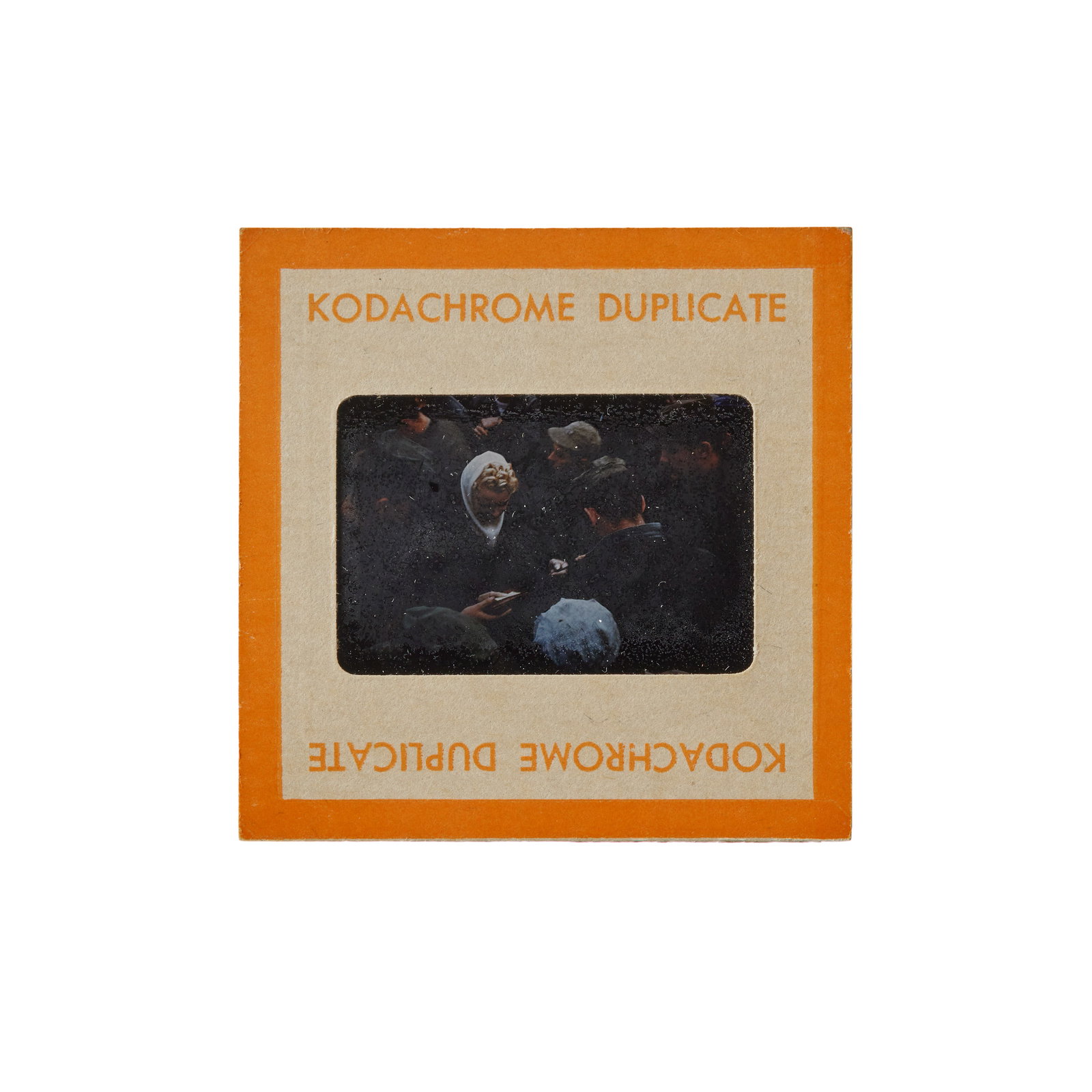 Marilyn Monroe | 1954 Never-Before-Seen Color Slide from Japan: An original print; housed in a cardboard sleeve reading in part on one side "Kodachrome Duplicate" and on the other "Made in U.S.A.," depicting the star signing autographs in Japan amongst a crowd of 