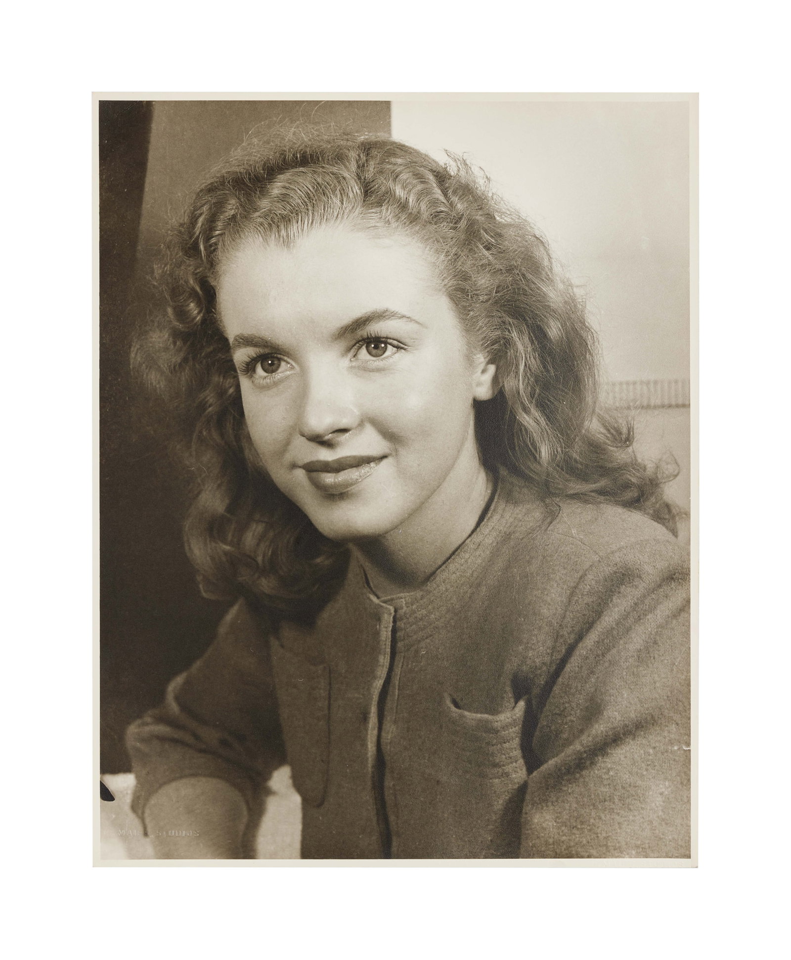 Marilyn Monroe | Circa 1944 Rare Black and White Photograph: An original print; matte finish, double-weight paper, depicting the teenager in one of her first professional headshots, way before she turned into Marilyn Monroe, blind stamps in both the left and ri