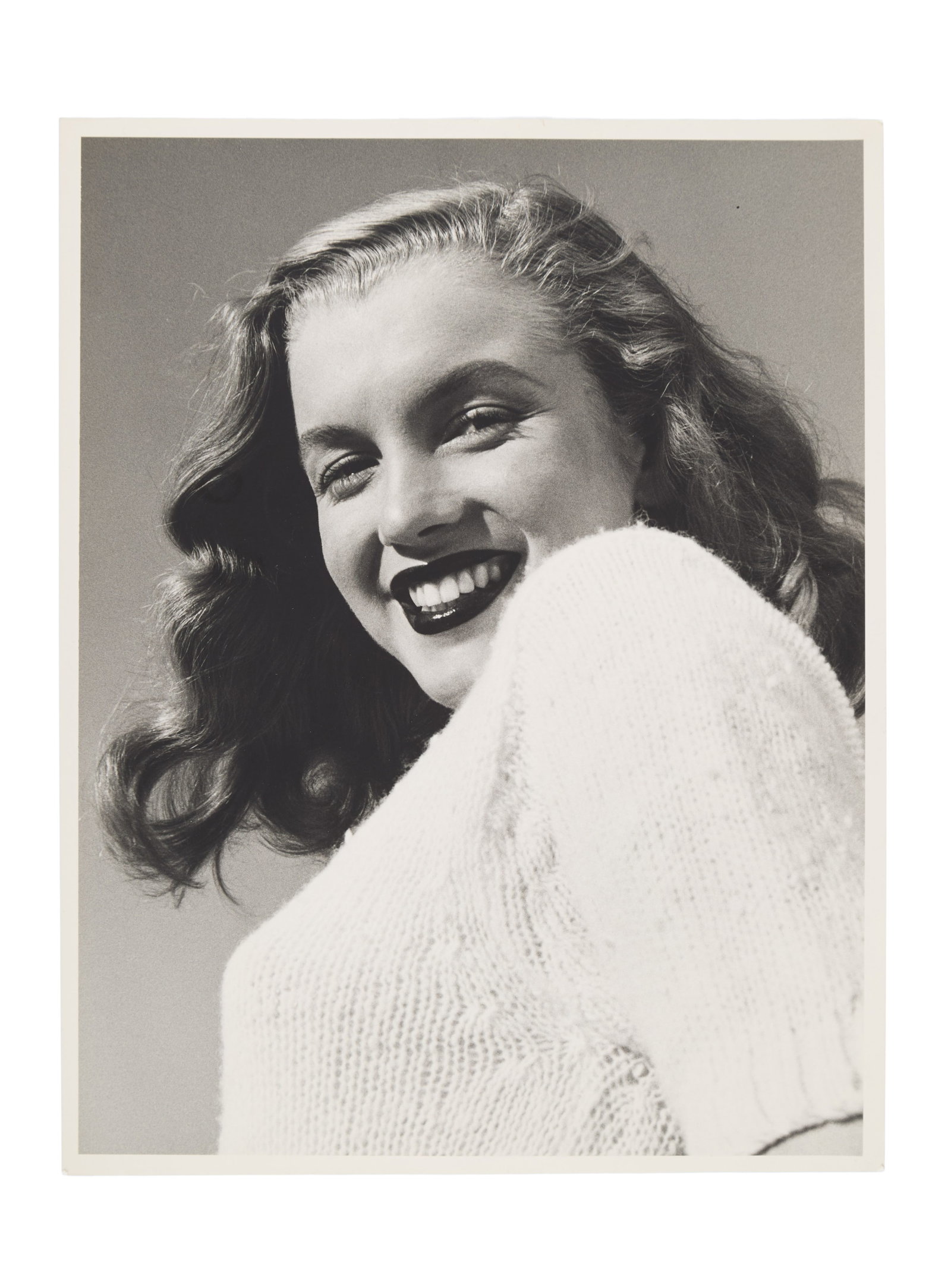 Marilyn Monroe | 1946/1990s Black and White Photograph by Joseph Jasgur: A circa 1990s later print; matte finish, double-weight paper, depicting a darling image of the smiling 19 year-old model wearing a white sweater; originally from the personal collection of Jasgur who 