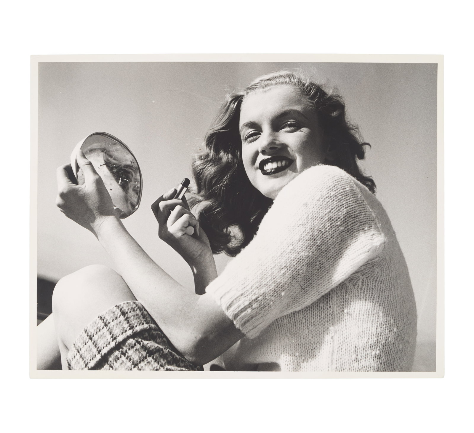 Marilyn Monroe | 1946/1990s Black and White Photograph by Joseph Jasgur: A circa 1990s later print; matte finish, double-weight paper, depicting a darling image of the 19 year-old model holding a mirror as she applies lipstick; originally from the personal collection of Ja