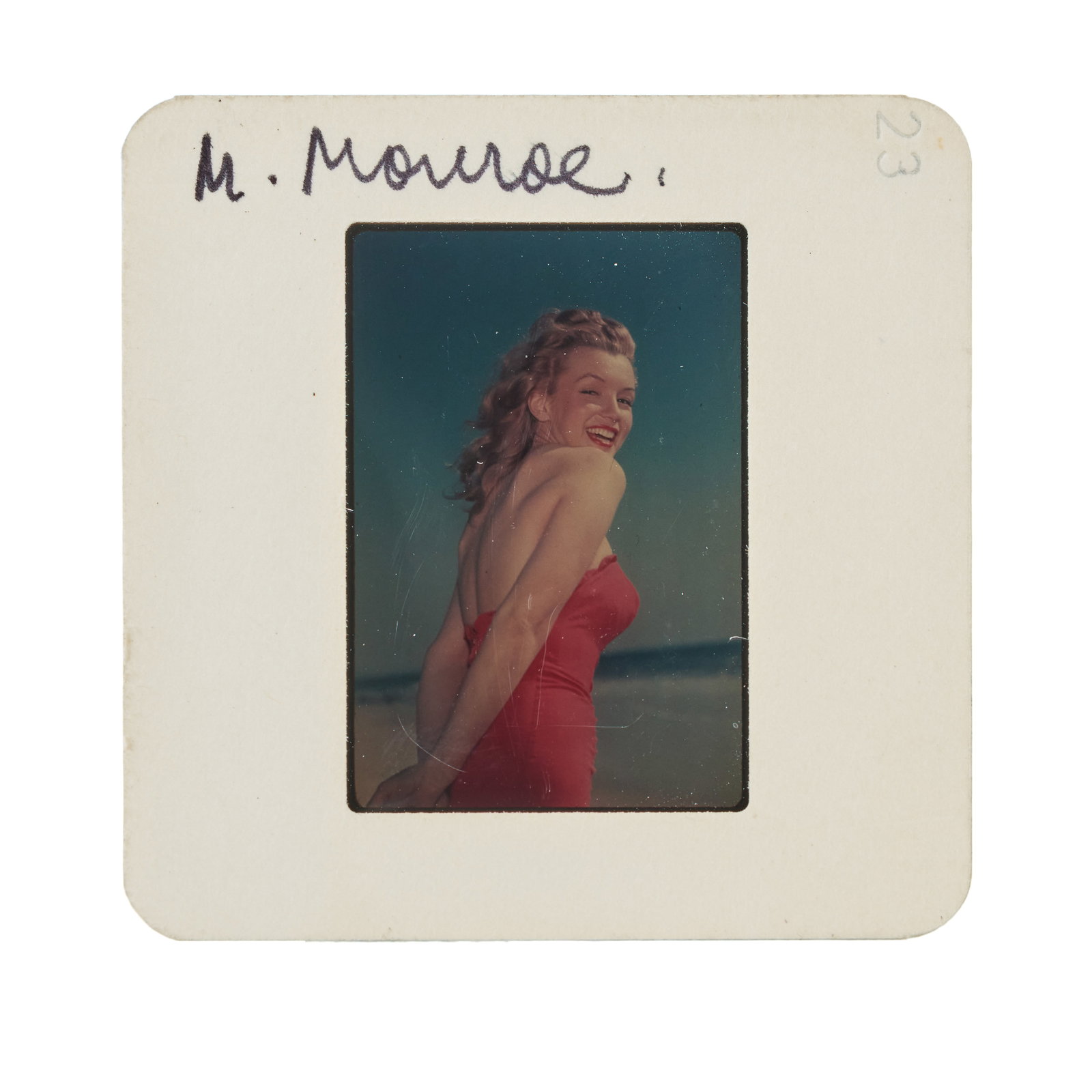 Marilyn Monroe | Circa 1946/1960s Rare Color Slide: A piece housed in a circa 1960s cardboard sleeve; depicting the then model wearing a red one-piece bathing suit as she poses on the beach; a somewhat scarce image that does not turn up that often.
