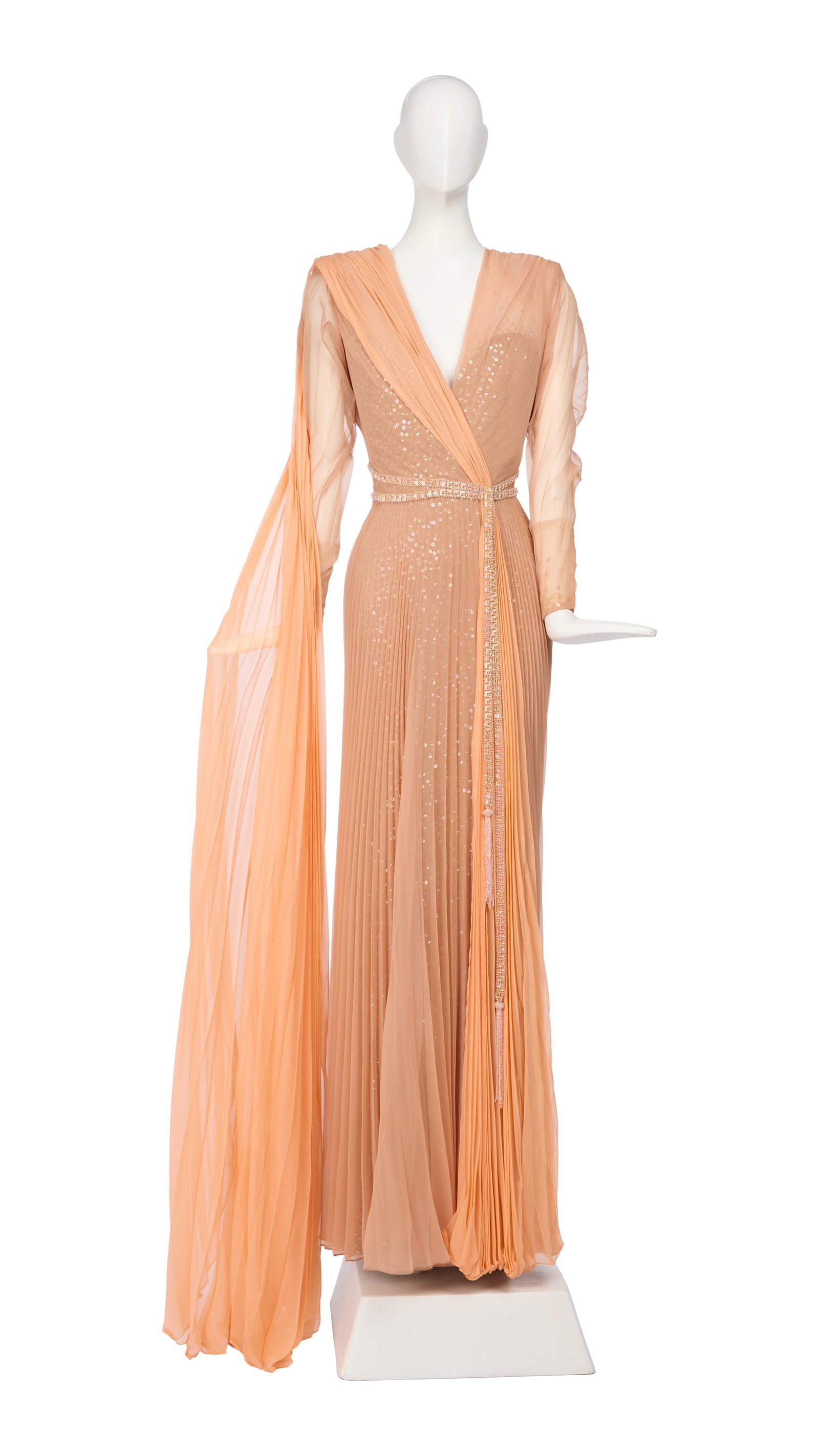 Ann-Margret | 1980 Gown by Bob Mackie Worn to the Academy Awards: A garment made of nude-colored silk jersey; adorned with clear sequins with a peach-colored pleated silk overlay, floor-length, gathered V-neck, long sleeves, double-beaded belt affixed at waist, trai