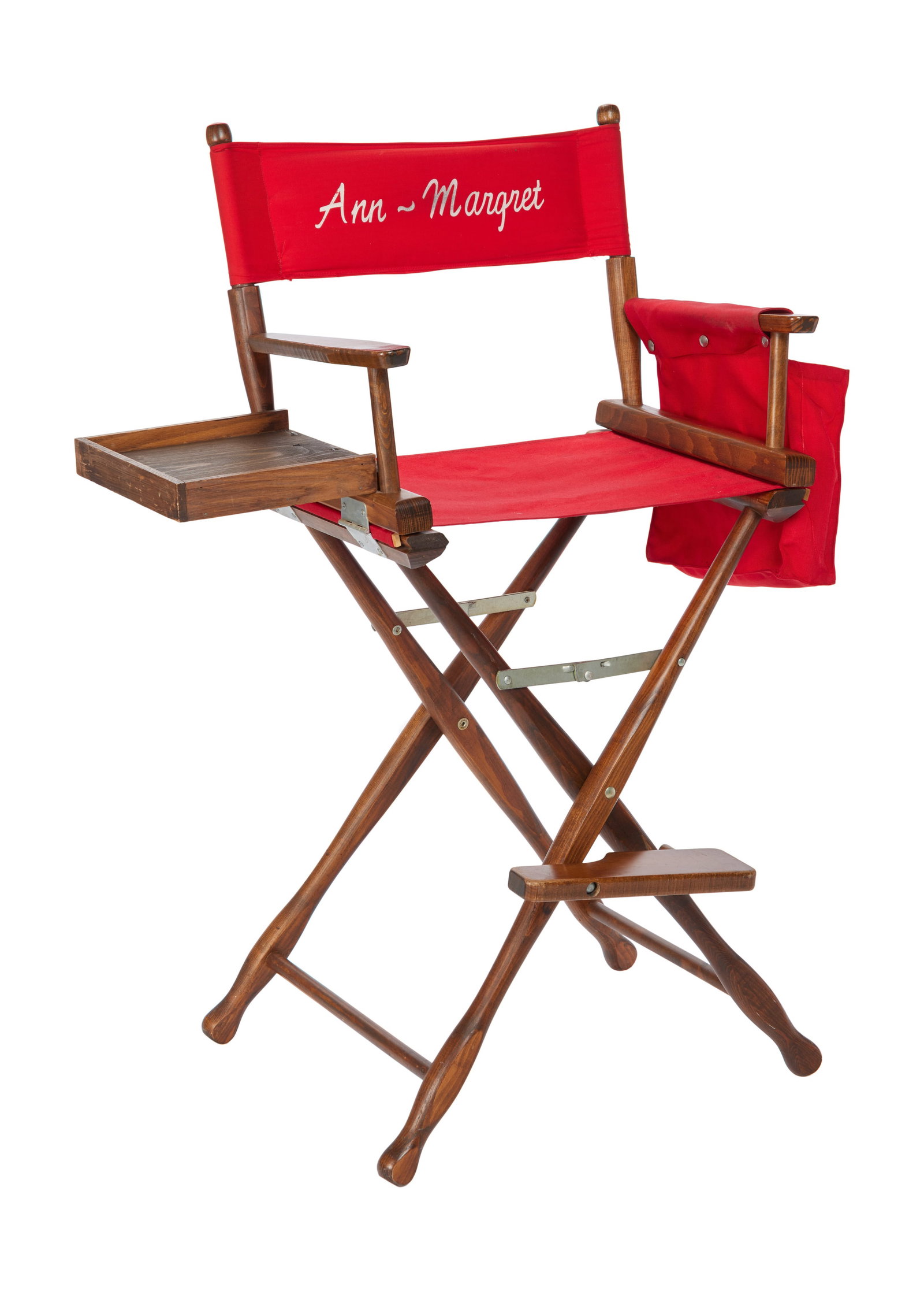 Ann-Margret | 1980s Director's Chair: A piece in the traditional folding design but a taller version; made of a dark-stained wood, added shelf affixed to right side for cups, etc., moveable footrest, red canvas seat, matching script