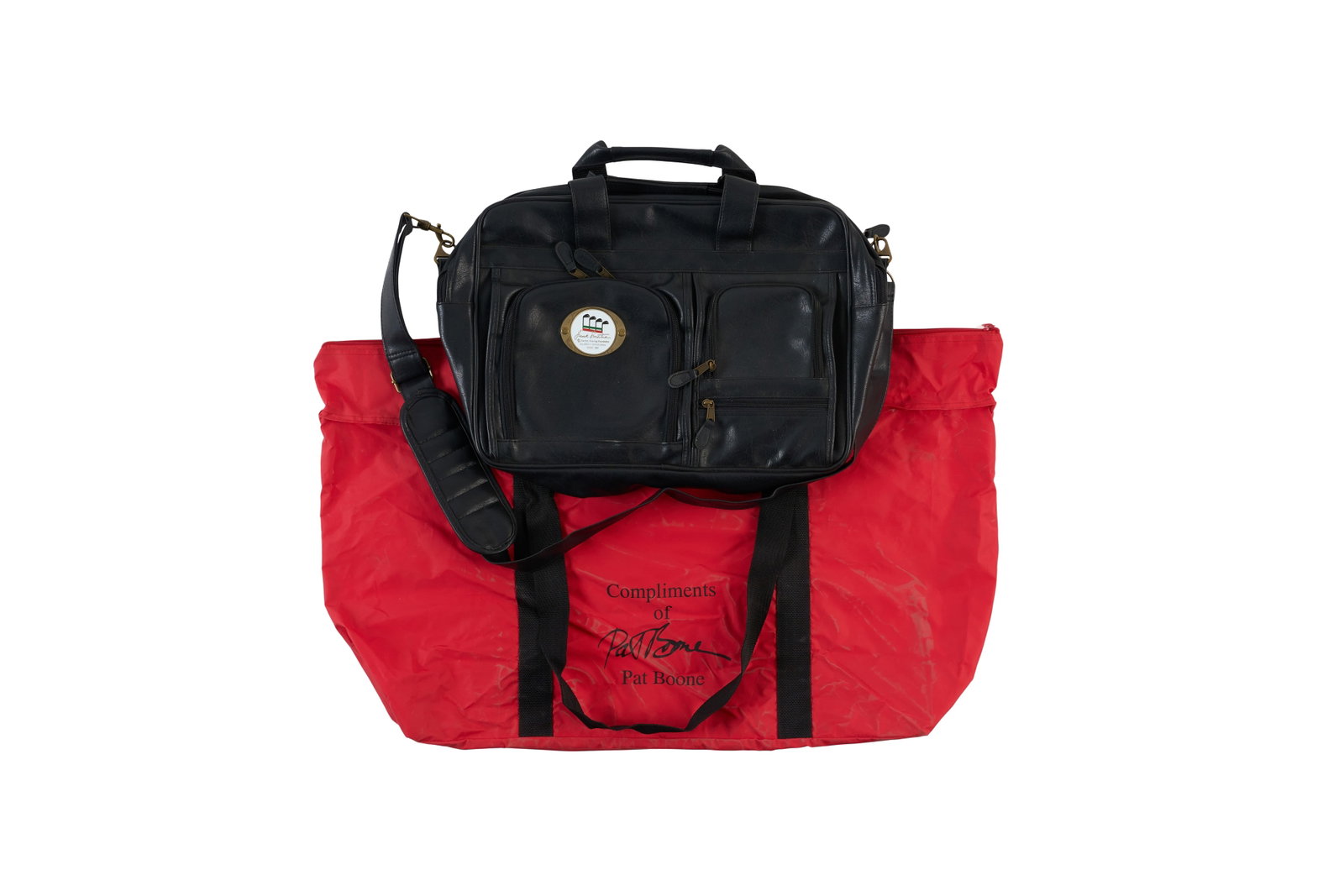 Frank Sinatra | 2000s Bags from Golf Invitationals: A group of two; both related to tournaments that took place long after the singer's death, but that are still named for him; the first a messenger bag made of black pleather, metal emblem on front rea