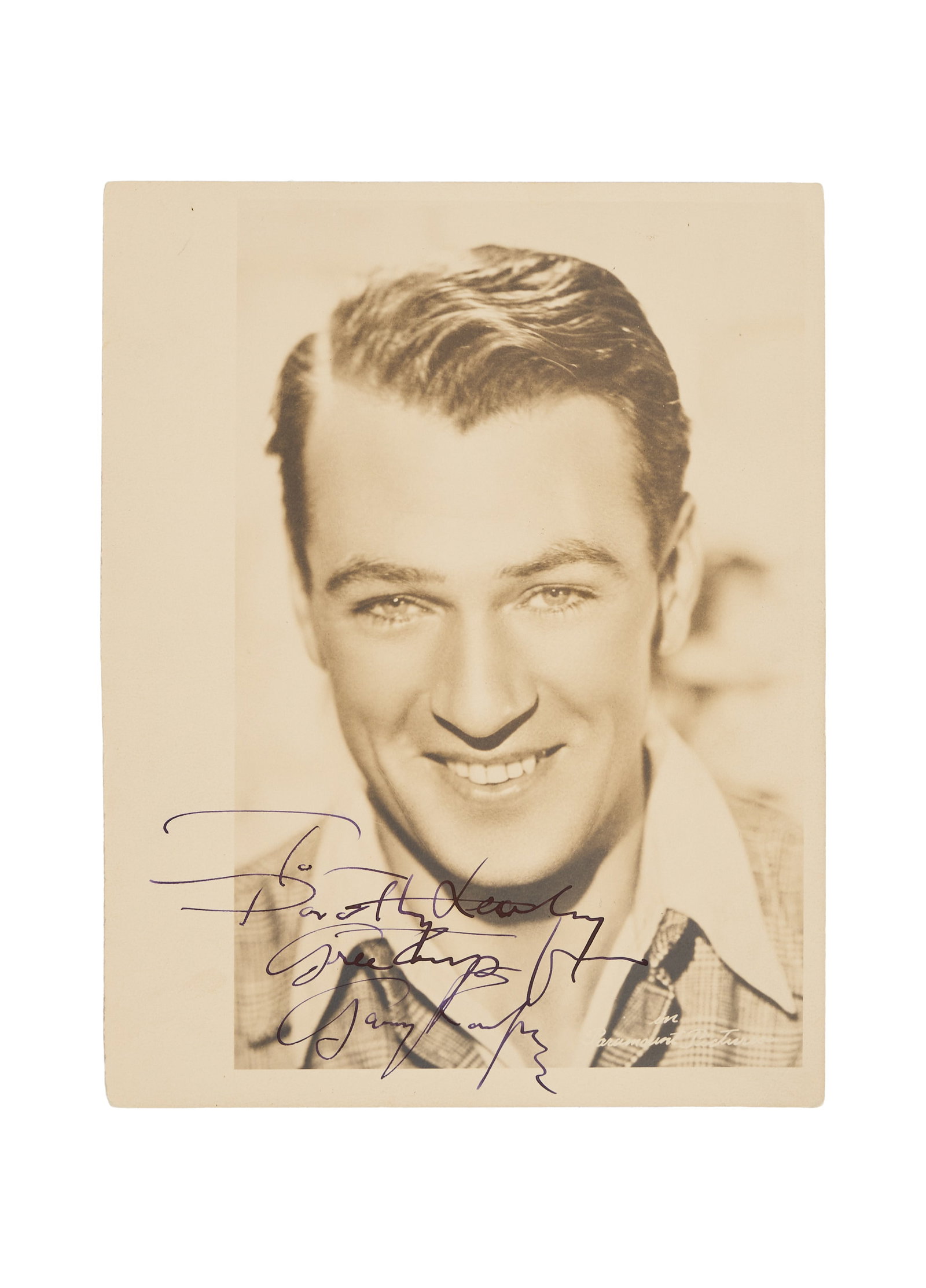 Gary Cooper | 1930s Signed Photo: An original print; matte finish, double-weight paper; signed in black fountain pen ink to the lower margin "To / Dorothy Leahy / Greetings from / Gary Cooper," "In Paramount Pictures" is printed to