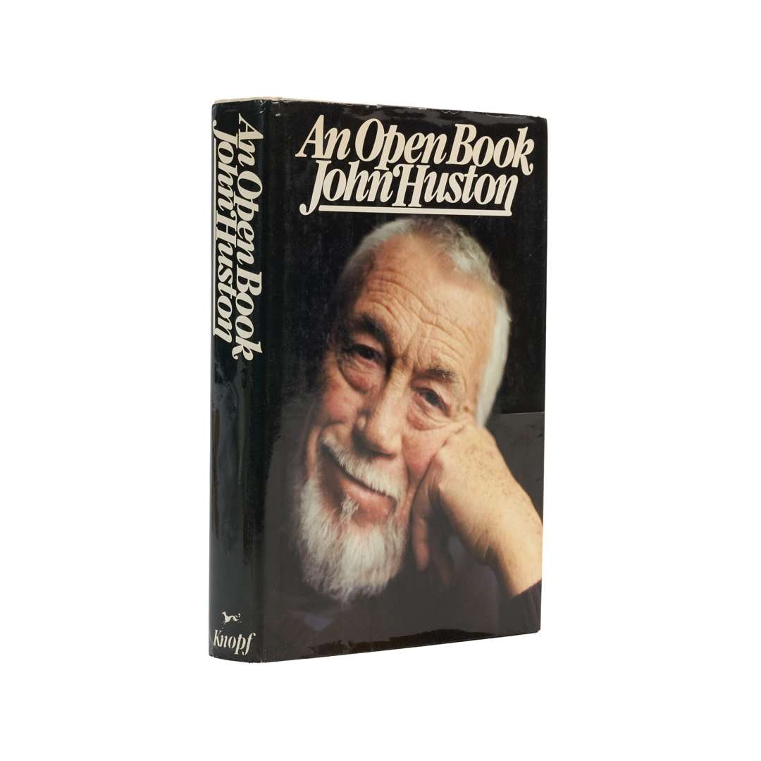 John Huston | Signed Copy of An Open Book: HUSTON, JOHN. An Open Book. New York: Alfred A. Knopf, 1980. 8vo. Original cloth backed board, unclipped dust jacket. Some toning and shelf wear to jacket. FIRST EDITION. Signed by Huston on half