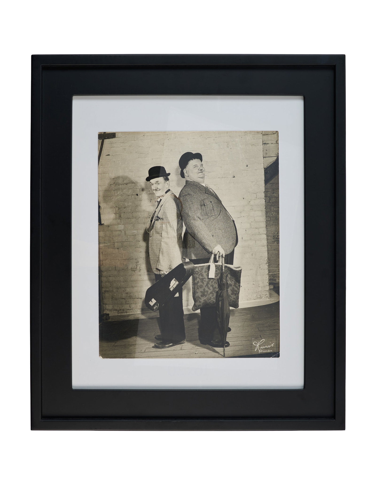 Laurel and Hardy | A Spot of Trouble Publicity Photo: A framed, vintage black and white publicity photo of Stan Laurel and Oliver Hardy from their performance of A Spot of Trouble in 1952. The photograph is marked "Rimis/London" on the lower right