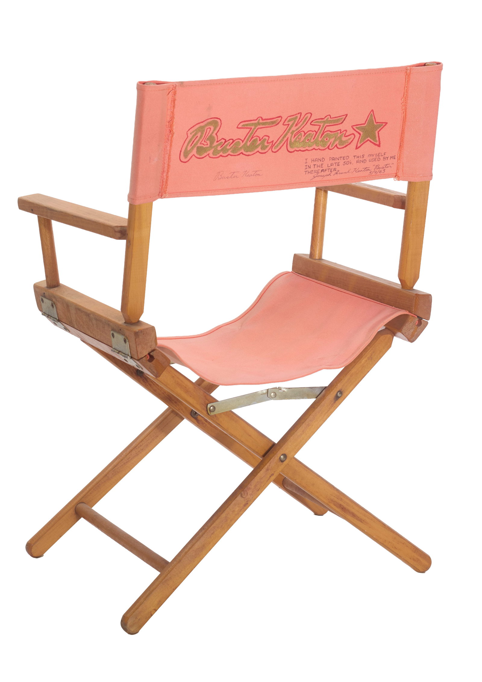 Buster Keaton | Buster Keaton Signed Director's Chair: A wooden director's style chair with a pink cloth seat and a pink Buster Keaton chairback, hand-painted and signed by Keaton (1895-1966). The pink chairback features the name "Buster Keaton" with a