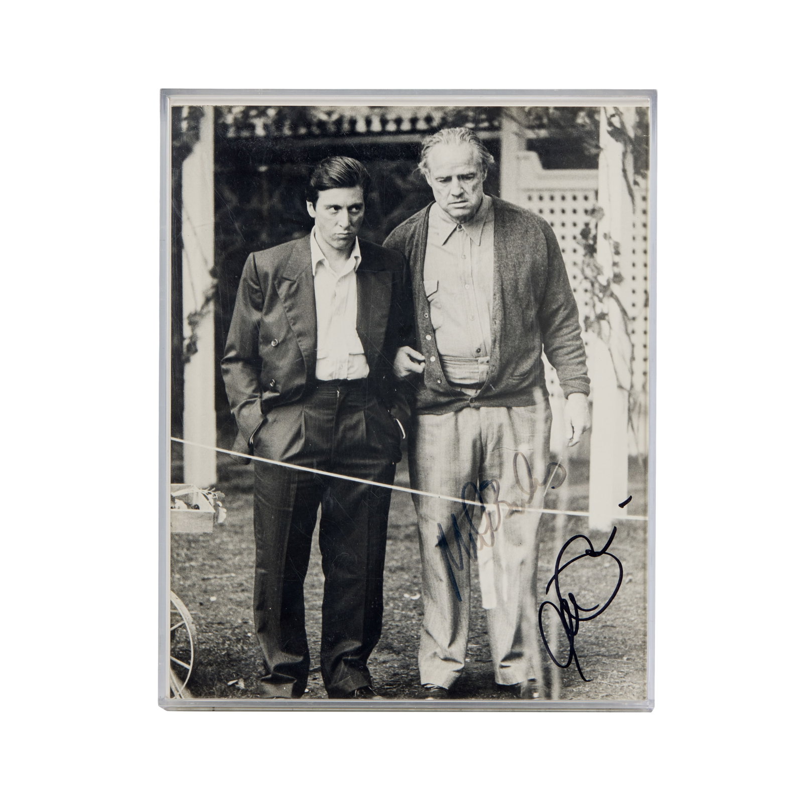 The Godfather | Photo Print Signed by Marlon Brando and Al Pacino: A black and white photo print on glassy Kodak paper; Al Pacino and Marlon Brando on the set of The Godfather (Paramount, 1972), an outstanding film even among two exemplary careers. Housed in a