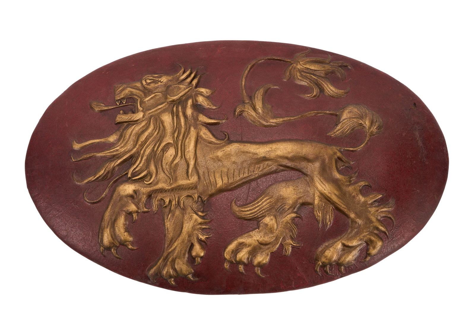 Game of Thrones | Lannister Shield with Lion: A House Lannister shield prop from the production of Game of Thrones (HBO, 2011-2019). Constructed from rubber, painted dark red and in gold-tone, and featuring the Lannister family sigil, a lion,