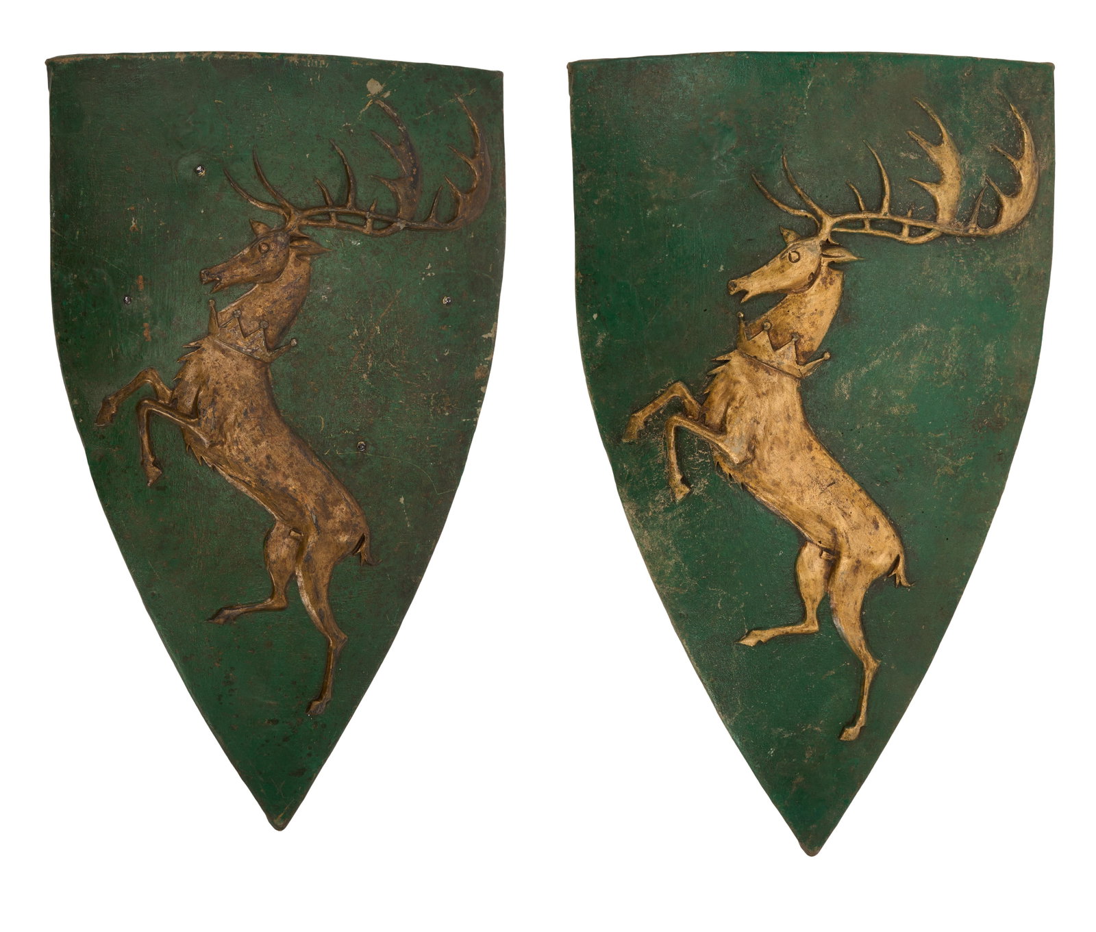 Game of Thrones | Renly Baratheon Shields with Stag (2): Two Renly Baratheon shield props from the production of Game of Thrones (HBO, 2011-2019). Constructed from rubber, painted green and in gold-tone, and featuring the Baratheon family sigil, a stag,