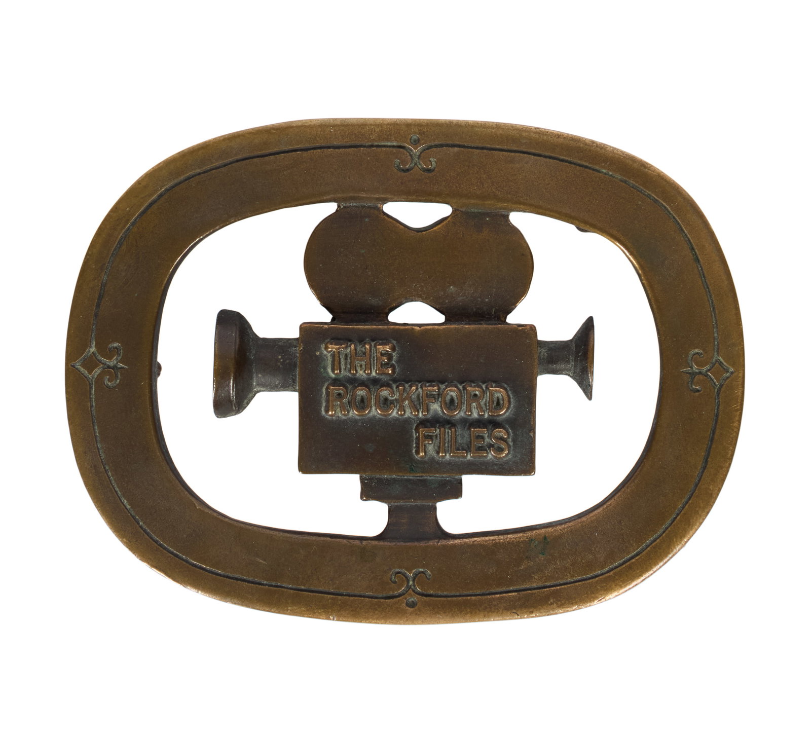 The Rockford Files | Al Shelton Numbered Belt Buckle : A metal belt buckle featuring the shape of a movie camera and the title of the James Garner-starring detective series The Rockford Files (NBC, 1974 - 1980). The buckle was made by noted Studio City, C