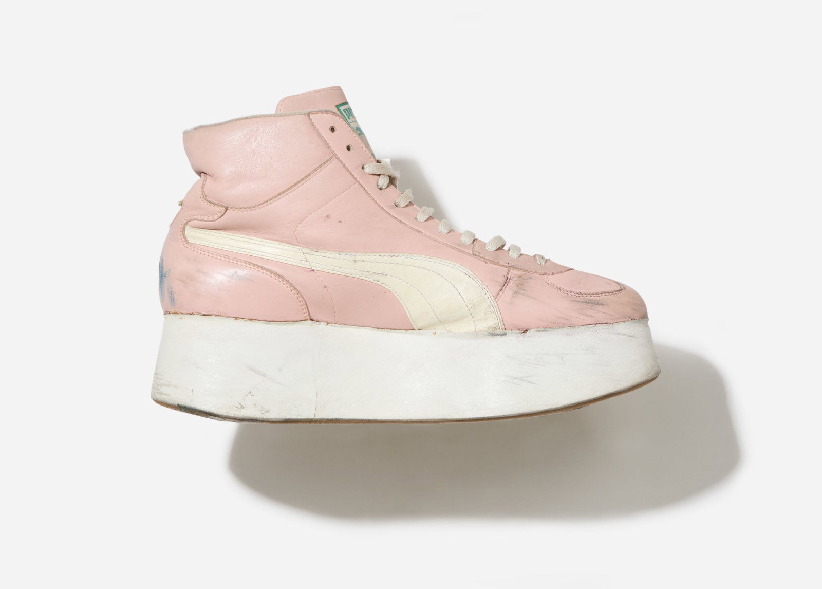Boy George | Puma Platform Sneakers: A pair of pink Puma high-top sneakers with a platform heel from the collection of Boy George. The sneakers are made of light pink leather with a contrasting white formstrip on both sides. They feature