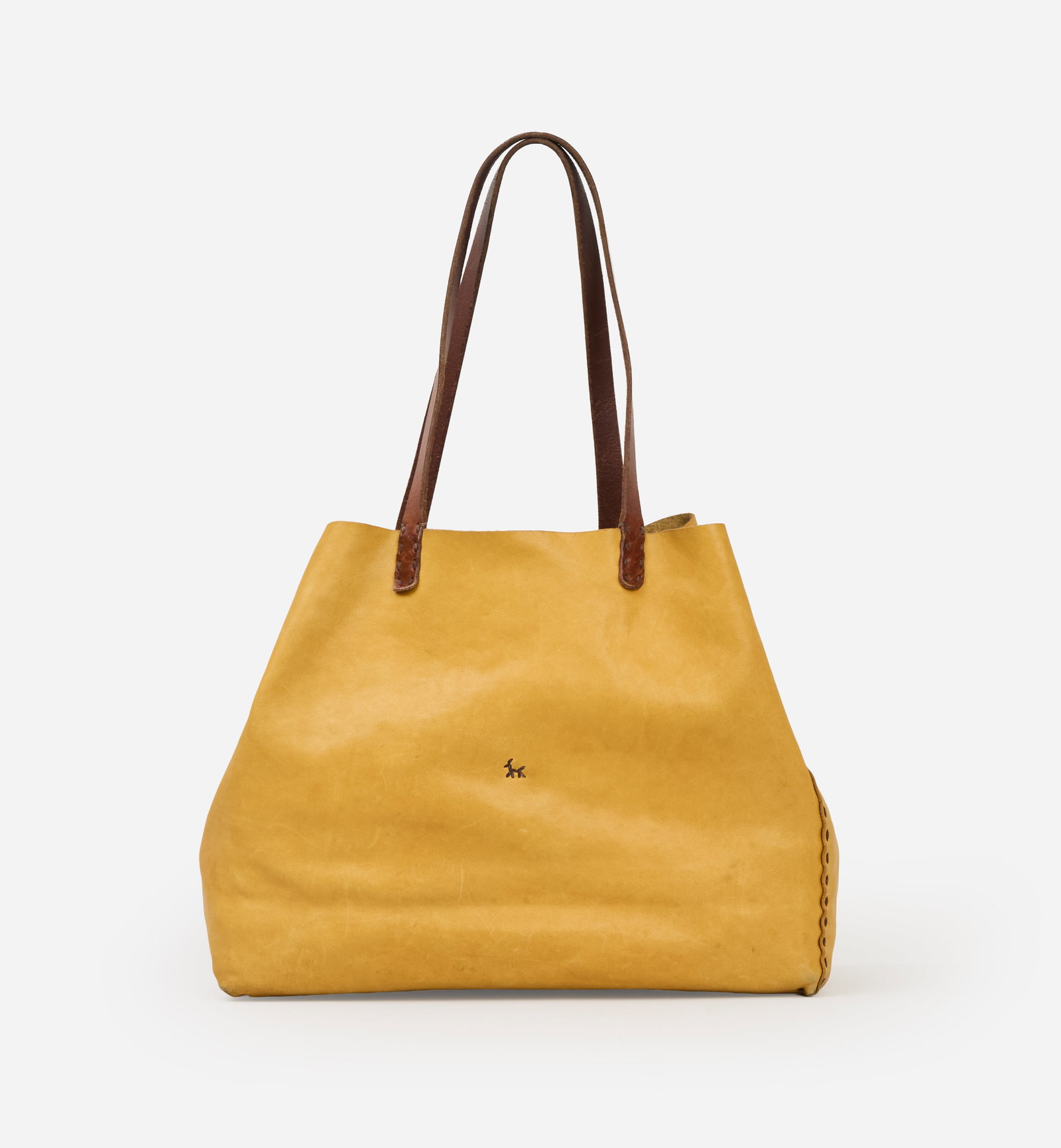 Henry Beguelin | Yellow Leather Tote: Henry Beguelin mustard yellow leather tote bag. The bag features an open-top silhouette with a single button-tab closure. The front is accented with the brand's signature hand-stitched stick-figure mo