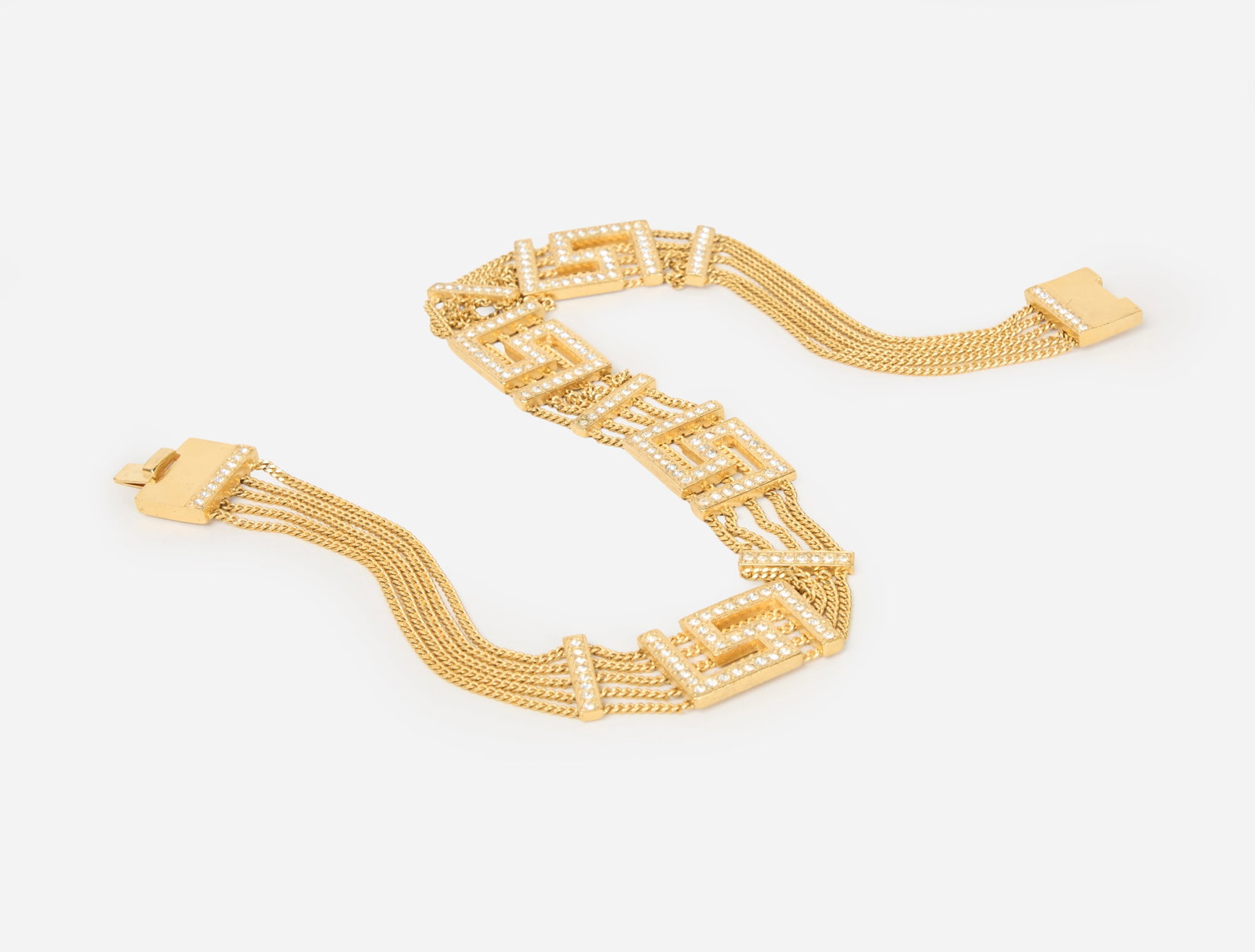 Gianni Versace | 1990s Greek Key Necklace: A 1990s gold-tone Gianni Versace Greek key necklace with five strands of gold chains with inlaid rhinestones on the on the Greek keys and bar spacers. There is a Gianni Versace engraved marker's