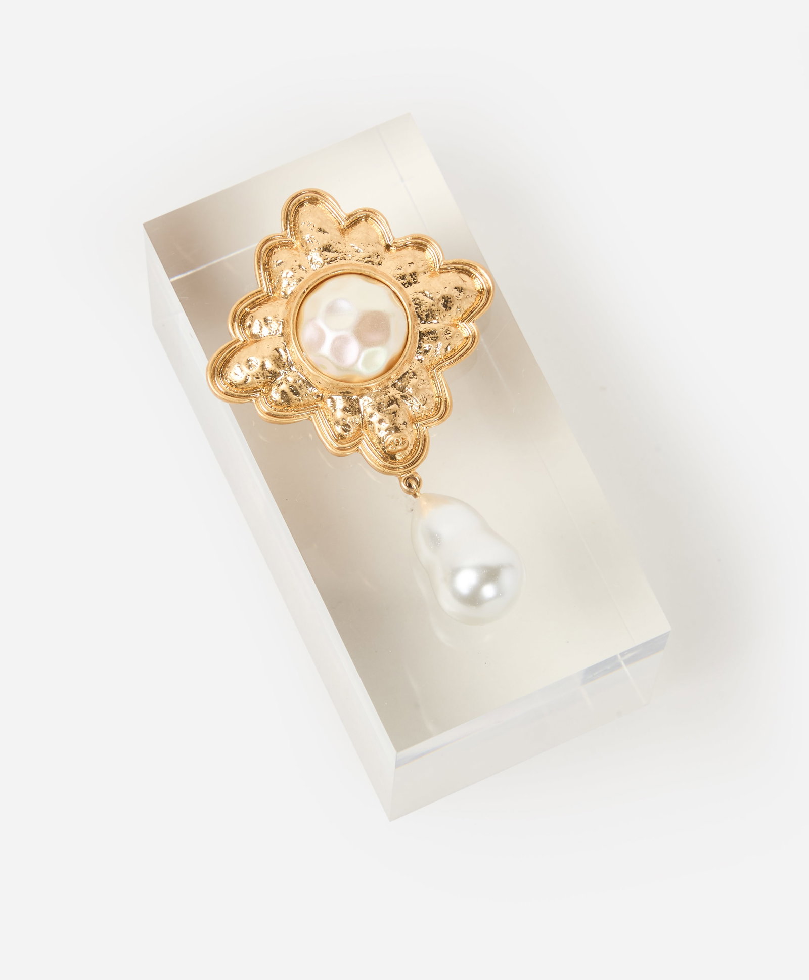 Chanel | Pearl Drop Brooch: Chanel pearl drop brooch. Centering upon a simulated mabé pearl, within a textured gold tone surround, suspending a large simulated baroque pearl drop, measures 3 1/4 x 2 inches. Marked