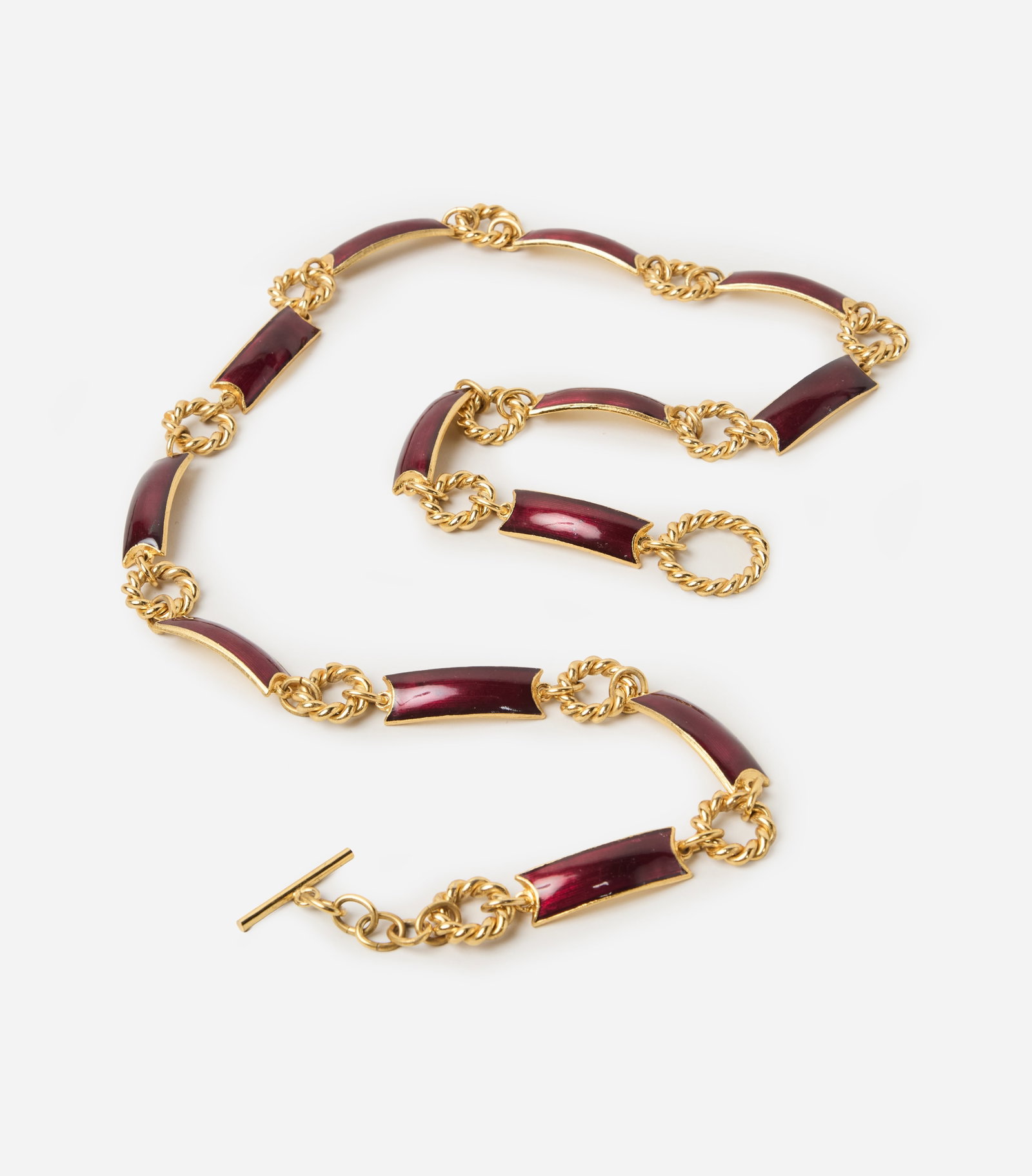 Gucci | 1970s Gold Chain Link Belt: A gold tone Gucci chain link with ring spacers and curved bar-links with burgundy enamel with a toggle closure. The bar of the toggle is engraved with Gucci and Italy as the country of origin. The