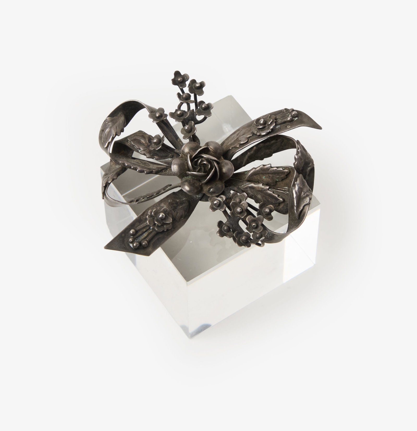 Hobé | Sterling Silver Bow Brooch: Hobé sterling silver bow brooch. The brooch is designed as a sculpted ribbon bow with a floral motif. It weighs 30 grams and measures 2 3/8 x 2 3/4 inches. Hobé Jewelry was founded in