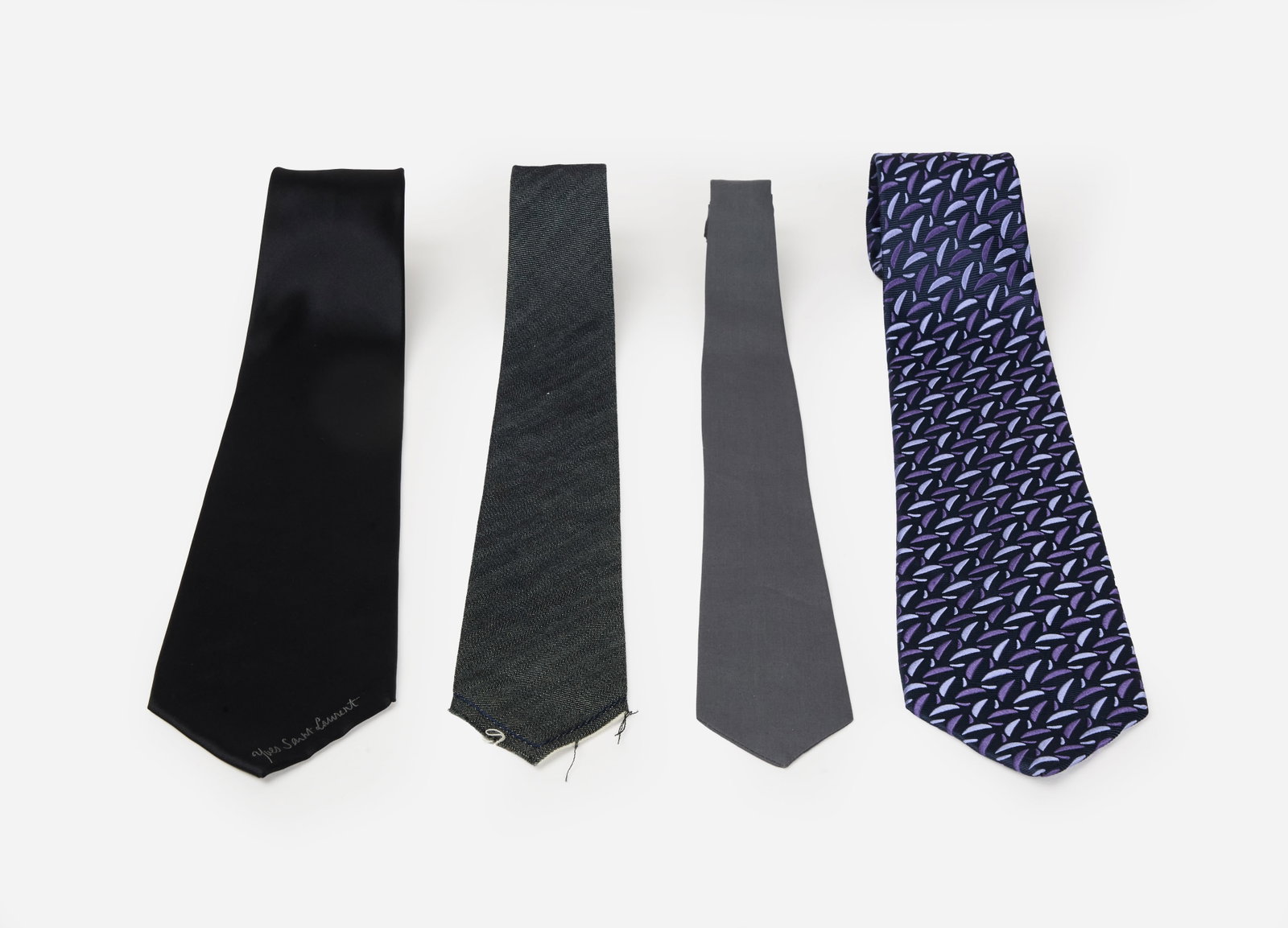 Group of Designer Ties | Yves Saint Laurent, Charvet Place Vendome, & Lanvin: A group of four designer ties featuring Yves Saint Laurent black tie, Charvet Place Vendome tie, a Lanvin grey tie, and an unlabeled grey skinny tie. The Yves Saint Laurent tie is composed of 100% sil