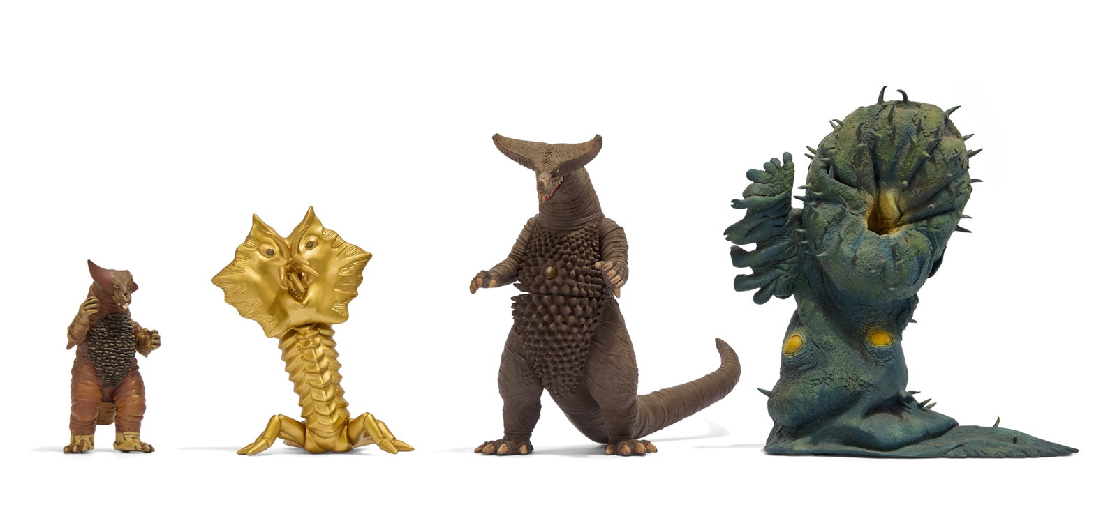 Sofubi | Kaiju Figures (4): A collection of four sofubi kaiju figures. Includes Greenmons (X-Plus), Gomora (Bandai), Alien Vira - Gold Variant (M1), and Battle Damaged Gomora (Banpresto). From the Estate of Sompote Sands