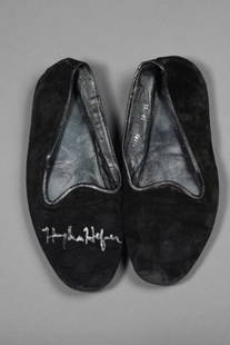 PLAYBOY: Hugh Hefner Signed Slippers: Personal Collection Men's black soft suede leather slippers by Neiman Marcus, signed on right front slipper in silver ink ("Hugh Hefner"), size 10, medium wear, overall good condition.This pair of