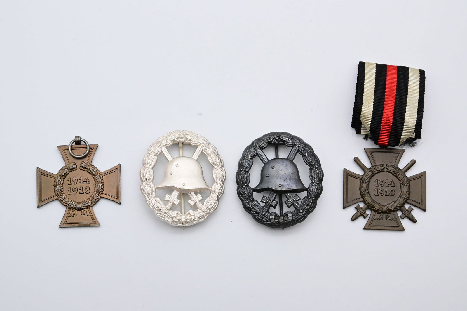 WK I. - Konvolut aus vier Abzeichen: WK I. - Konvolut aus vier Abzeichen - Verwundetenabzeichen für die Armee und Kolonialtruppen 1918 in Schwarz – durchbrochen- Verwundetenabzeichen für die Armee und Kolonialtruppen