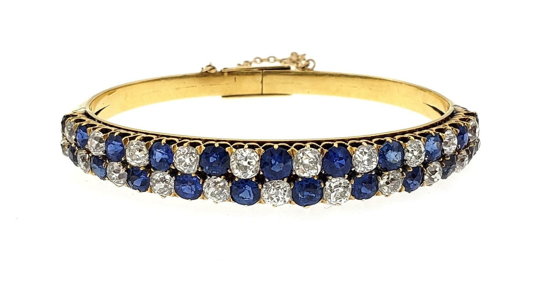 Victorian 18k Yellow Gold Diamond Sapphire Bangle Bracelet: Victorian 18k Yellow Gold Diamond Sapphire Bangle Bracelet This exquisite Victorian Era bangle bracelet is a stunning piece crafted from 18k yellow gold. The bracelet features a beautifully curved fro