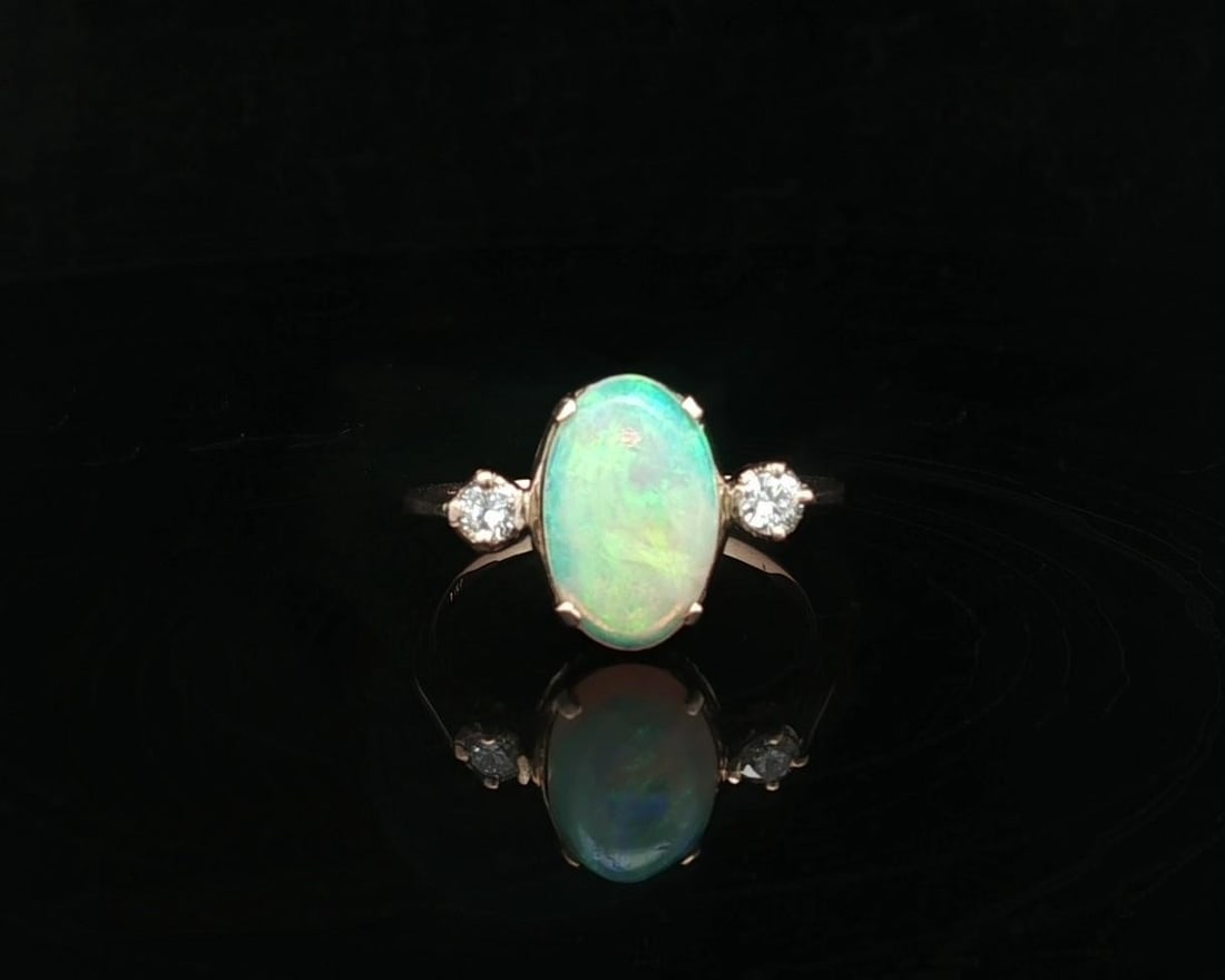 Vintage 9k Yellow Gold Opal and Diamond Cocktail Ring: Vintage 9k Yellow Gold Opal and Diamond Cocktail Ring This exquisite vintage ring showcases a stunning oval cabochon opal surrounded by two brilliant round diamonds, all elegantly set in solid 9k yell