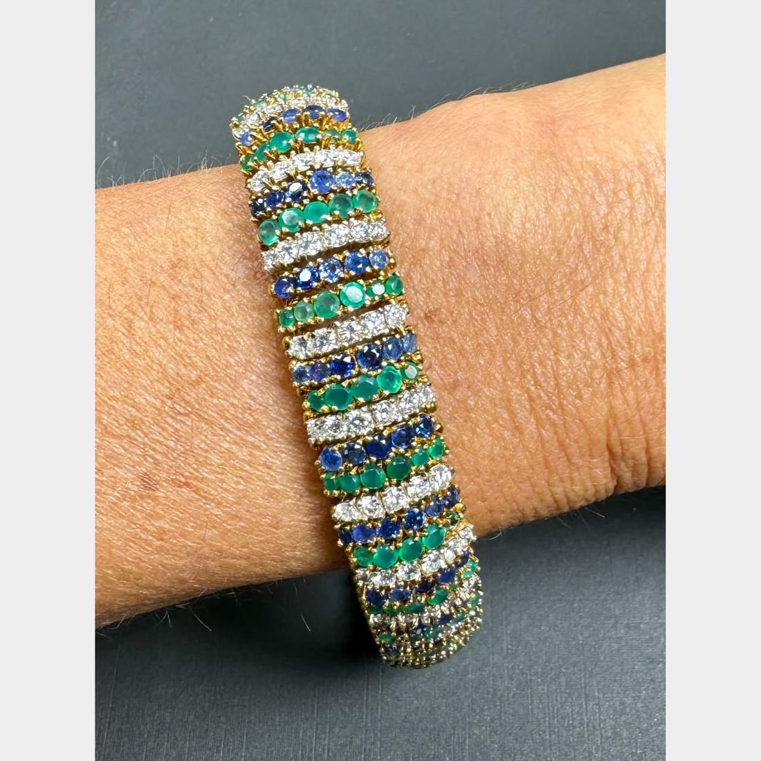 1960's 18K Yellow Gold Bracelet with Diamonds Sapphires and Green Onyx: 1960's 18K Yellow Gold Bracelet with Diamonds Sapphires and Green Onyx This exquisite 1960's bracelet is crafted from 18K yellow gold and features a stunning combination of diamonds, sapphires, and gr