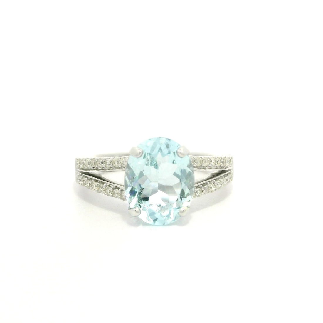14k White Gold Modern Split Shank Aquamarine Diamond Cocktail Ring: 14k White Gold Modern Split Shank Aquamarine Diamond Cocktail Ring This stunning cocktail ring features a captivating oval aquamarine, boasting a brilliant blue hue that measures approximately 10 x 8m
