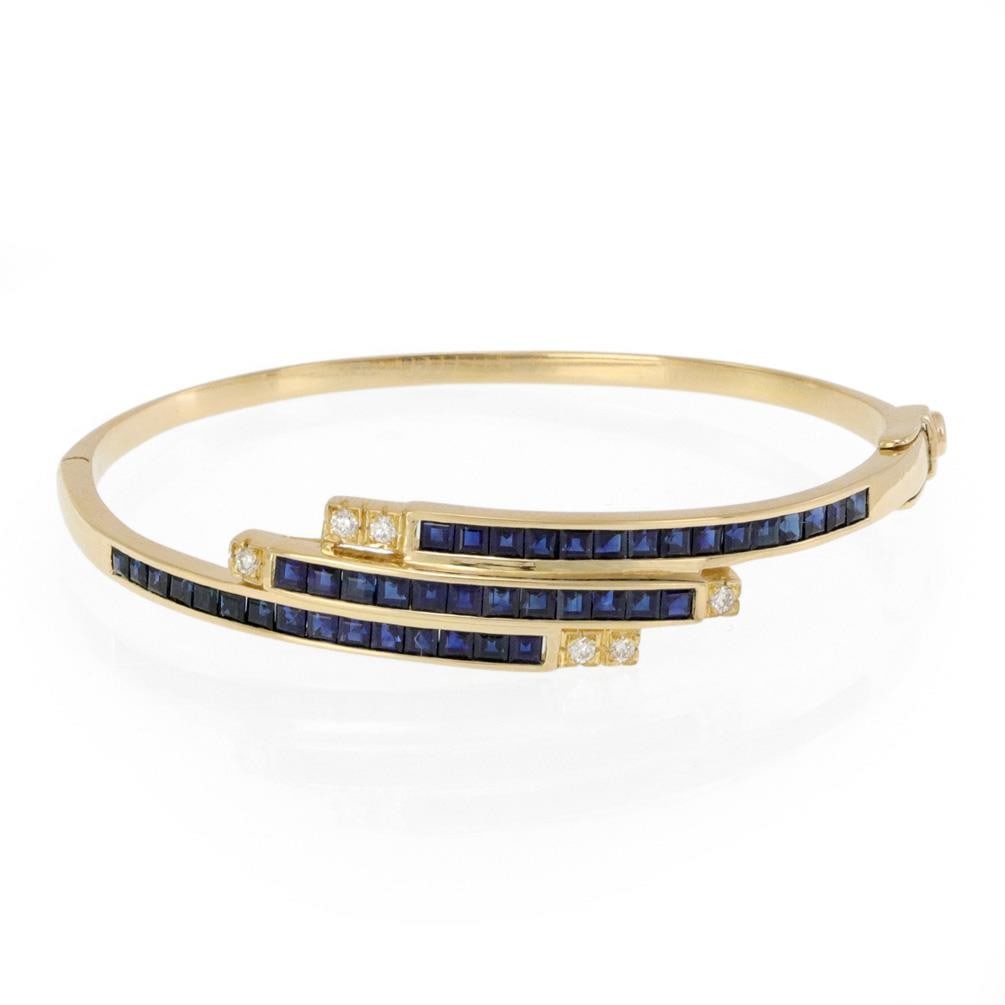 Elegant Sapphire Diamond Bypass Bracelet in 18k Yellow Gold: Elegant Sapphire Diamond Bypass Bracelet in 18k Yellow Gold This exquisite Sapphire Diamond Bracelet features a stunning bypass design crafted from 18k yellow gold. The bracelet showcases three rows o
