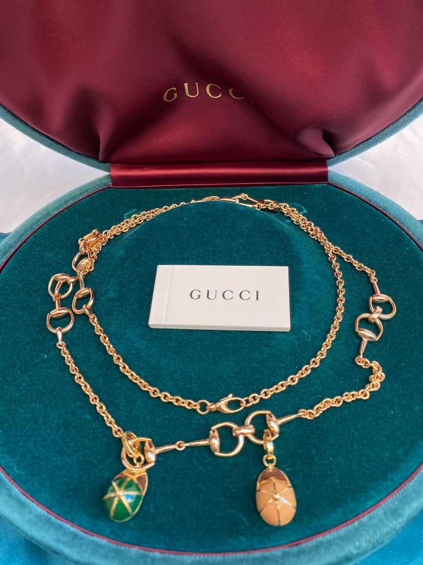 Gucci 18K Gold Enamel Necklace with Charms and Box: Gucci 18K Gold Enamel Necklace with Charms and Box Discover the elegance of this brand new Gucci necklace, expertly crafted from 18K yellow gold and adorned with charming enameled hat motifs. This stu