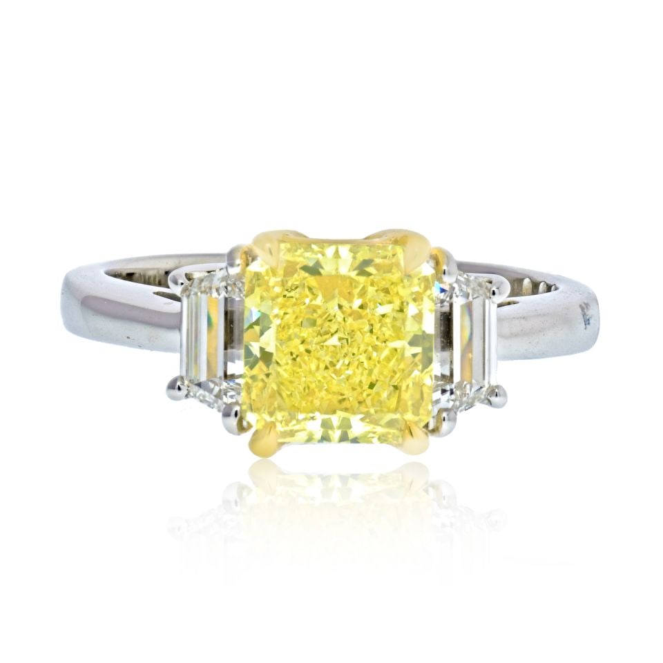 2.13 Carat Fancy Yellow Diamond Ring GIA Platinum 18K Gold: 2.13 Carat Fancy Yellow Diamond Ring GIA Platinum 18K Gold This stunning three-stone engagement ring features a radiant cut Fancy Yellow diamond at its center, weighing 2.13 carats, flanked by trapezo