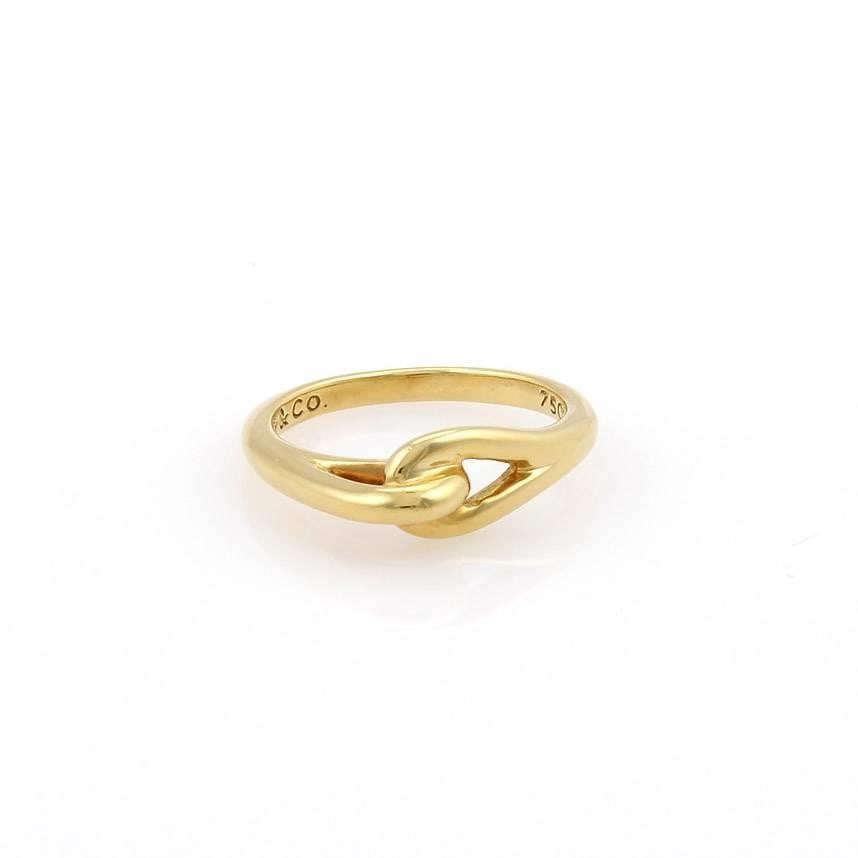 Tiffany & Co. 18k Yellow Gold Double Loop Interlaced Ring: Tiffany & Co. 18k Yellow Gold Double Loop Interlaced Ring This exquisite Interlaced Ring by Tiffany & Co. is a stunning piece crafted from 18k yellow gold, featuring a beautifully polished finish. The