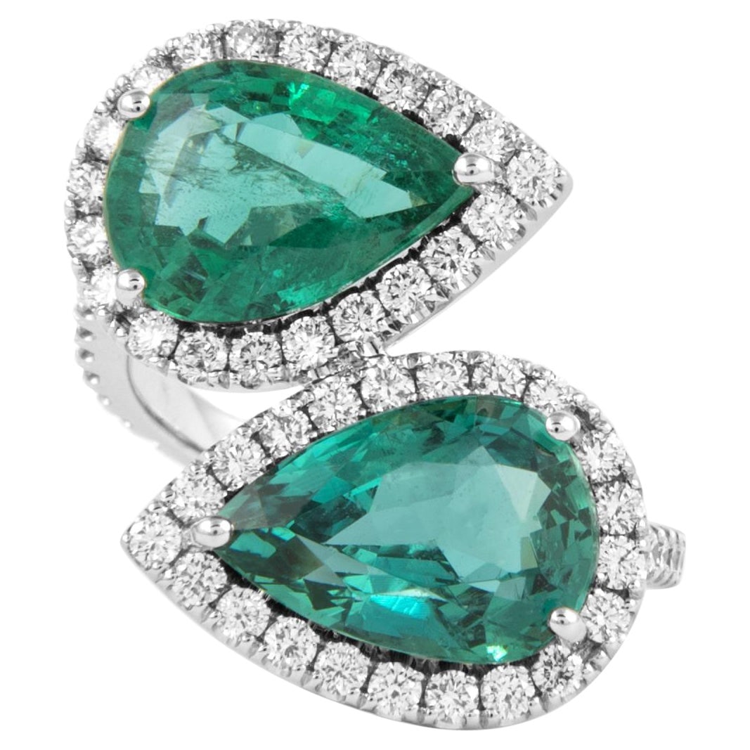 6.33ct Emerald & Diamond 18k White Gold Bypass Ring: 6.33ct Emerald & Diamond 18k White Gold Bypass Ring This exquisite GIA certified bypass ring showcases a stunning combination of a 6.33 ct pear cut emerald and 60 round brilliant diamonds totaling 1.0