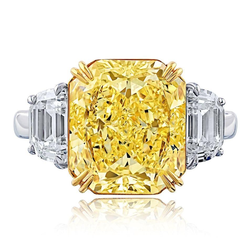 5.7ct Fancy Intense Yellow Radiant Cut Diamond Engagement Ring: 5.7ct Fancy Intense Yellow Radiant Cut Diamond Engagement Ring This exquisite three stone engagement ring showcases a stunning 5.70 carat Fancy Intense Yellow Radiant Cut diamond at its center, comple