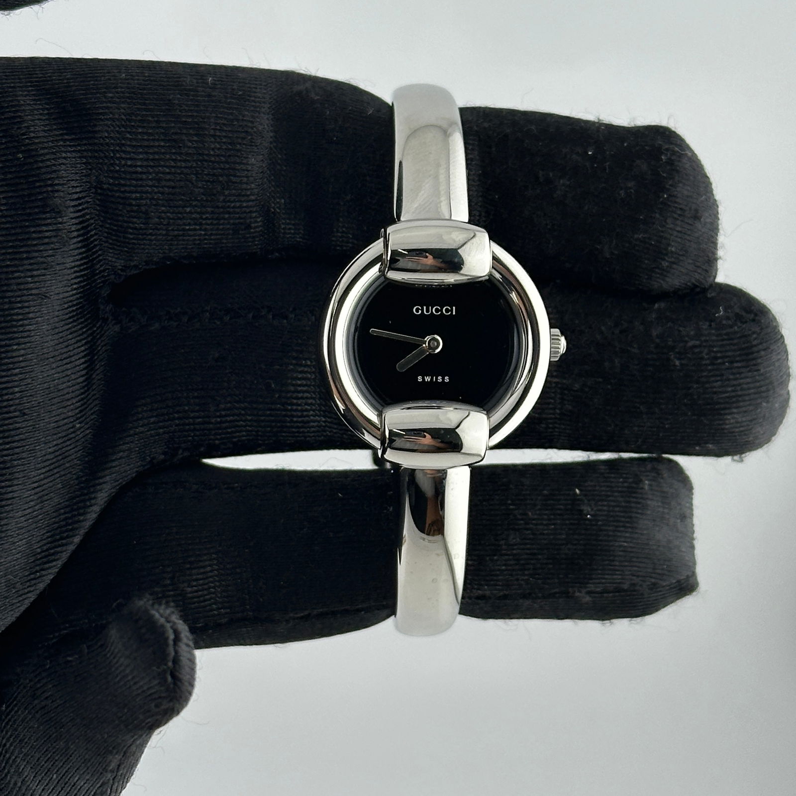 Ladies Bangle Watch with Black Dial Reference 1400L: Ladies Bangle Watch with Black Dial Reference 1400L This ladies' Gucci watch features a black dial and a bangle-style bracelet. The timepiece is identified by reference number 1400L and has no bezel,