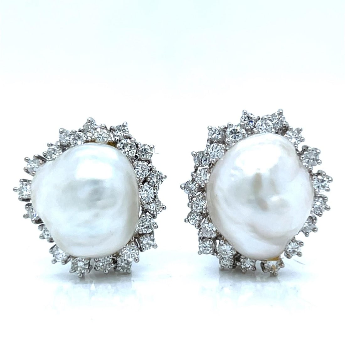 Pair of South Sea Pearl and Diamond Earrings in 18K White Gold from the 1960s: Pair of South Sea Pearl and Diamond Earrings in 18K White Gold from the 1960s Elegant 1960's earrings crafted in 18K white gold, featuring two South Sea pearls accented by forty-six diamonds with a co