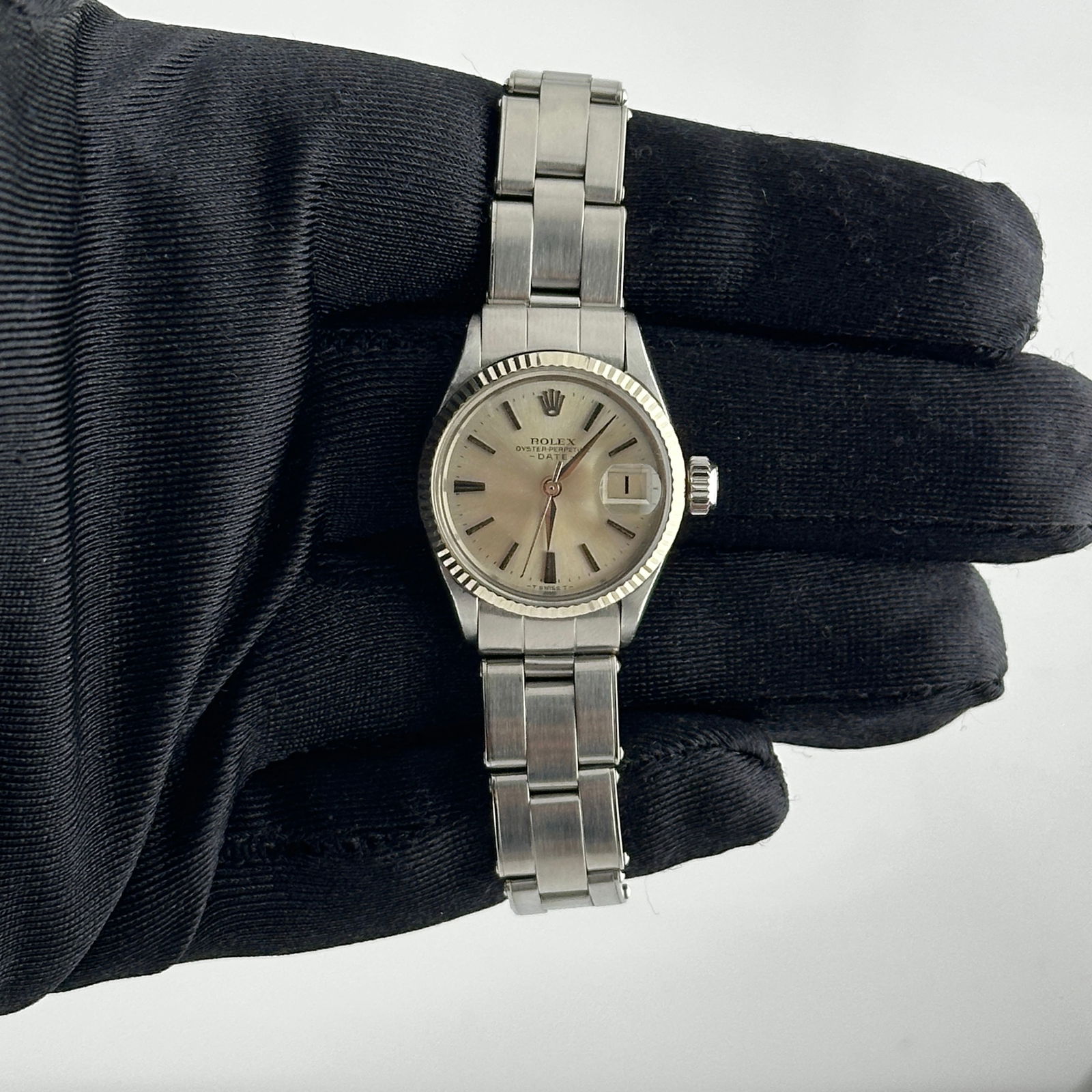 Ladies Oyster Perpetual Date 6517 Silver Stick Dial Watch with Papers 1985: Ladies Oyster Perpetual Date 6517 Silver Stick Dial Watch with Papers 1985 This ladies' Rolex Oyster Perpetual Date features a refined silver stick dial and a classic fluted bezel, paired with an