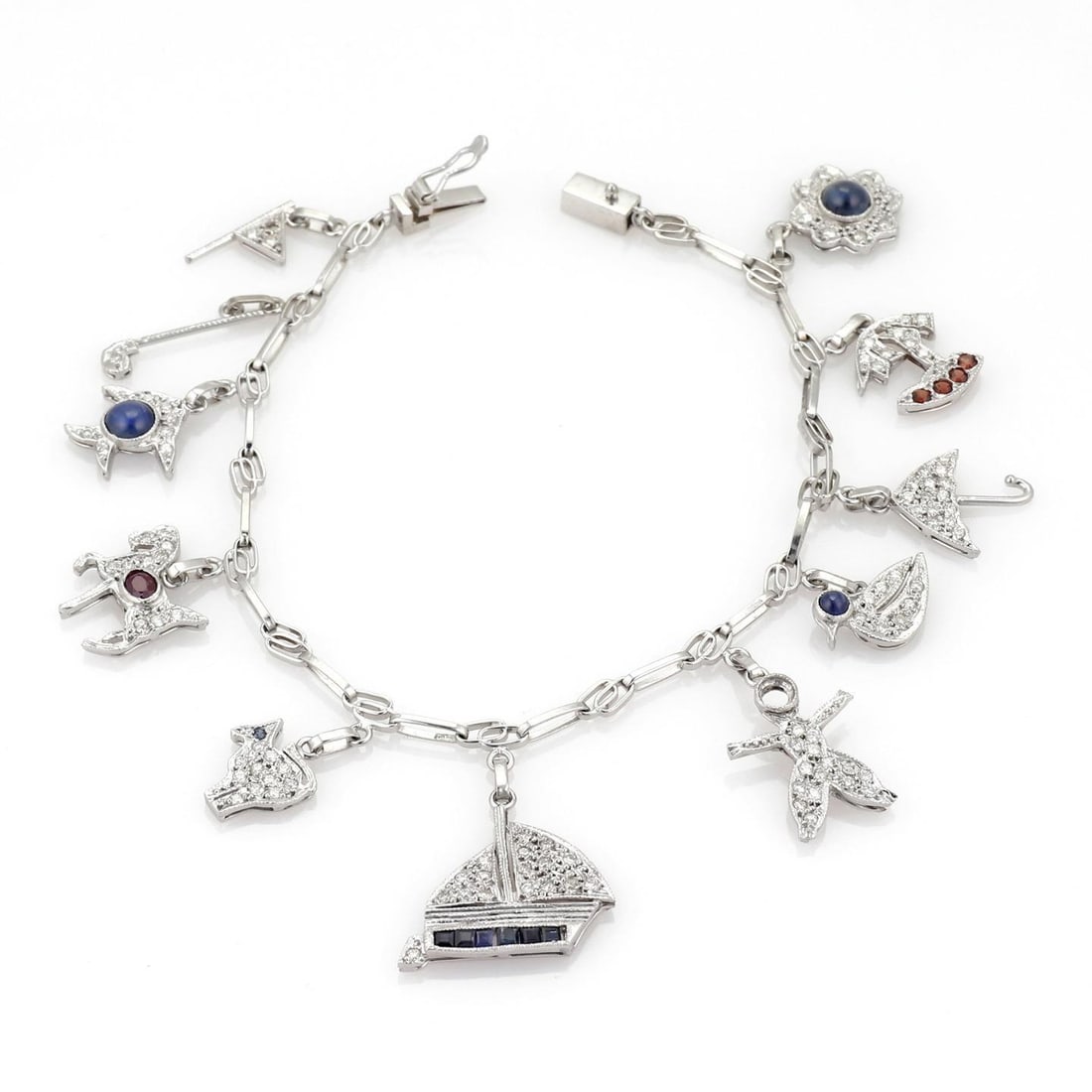 Platinum Bracelet with 11 Charms Diamonds Sapphires Rubies Garnets: Platinum Bracelet with 11 Charms Diamonds Sapphires Rubies Garnets This stunning platinum bracelet features 11 charming dangling designs, including assorted animal shapes complemented by umbrellas and