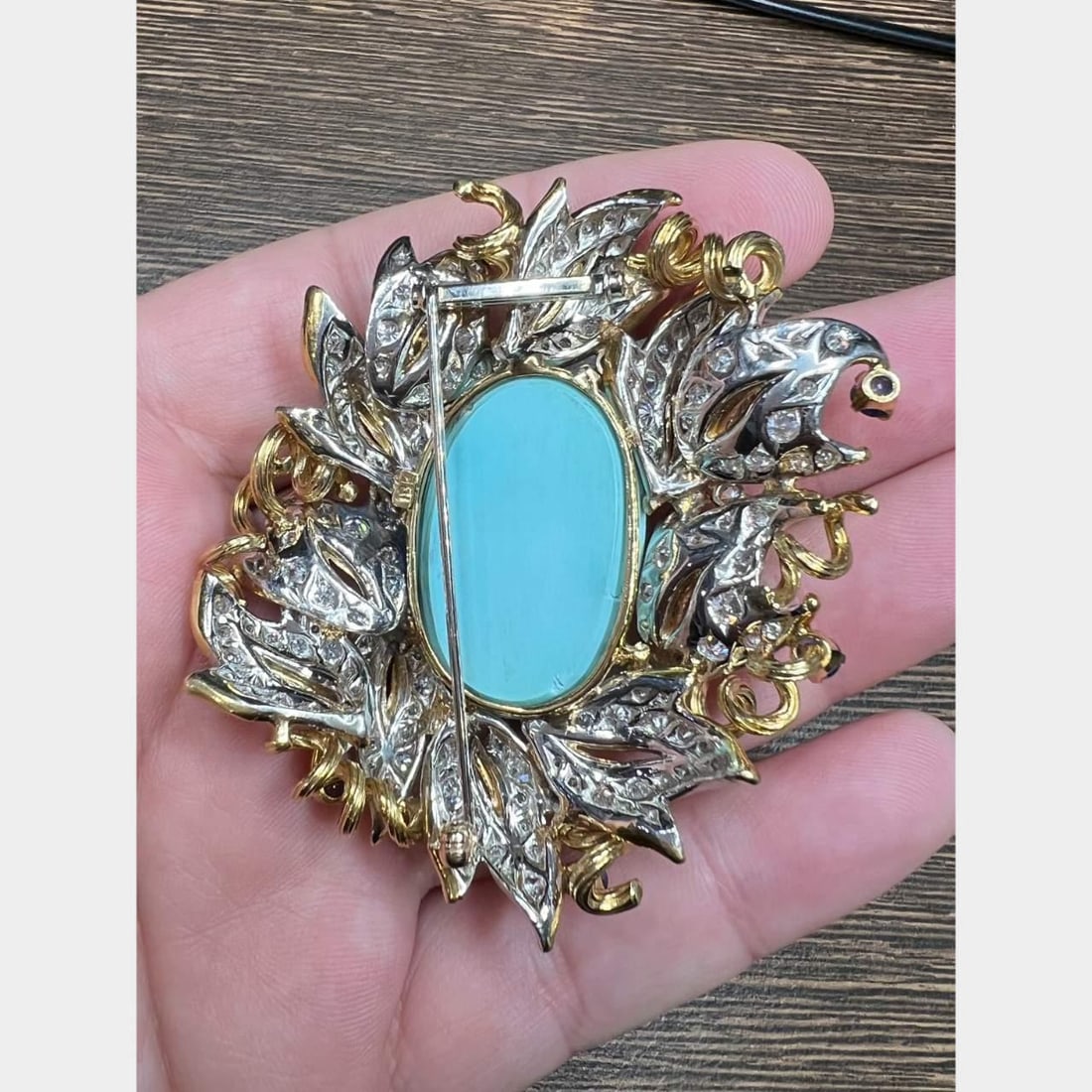 Elegant 18K Yellow Gold Turquoise Diamond Sapphire Brooch: Elegant 18K Yellow Gold Turquoise Diamond Sapphire Brooch This exquisite brooch is crafted from 18K yellow gold and features a stunning natural turquoise centerpiece measuring approximately 31 x 21 mm