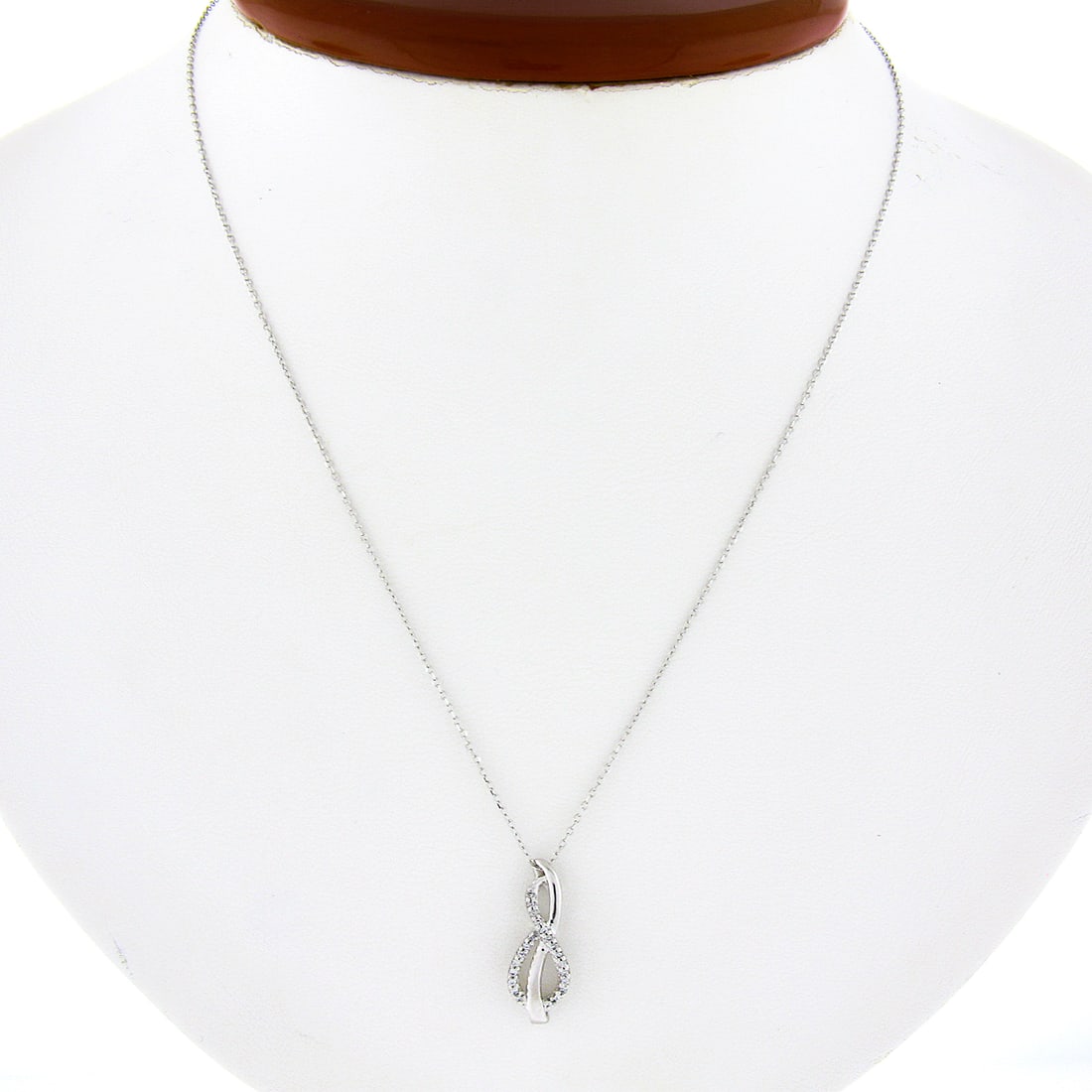 10k White Gold Mom's Infinity Pendant with 0.06ctw Diamonds & 14k Adjustable Chain: 10k White Gold Mom's Infinity Pendant with 0.06ctw Diamonds & 14k Adjustable Chain This exquisite pendant features a delicate open infinity design crafted from solid 10k white gold, adorned with 22 pe