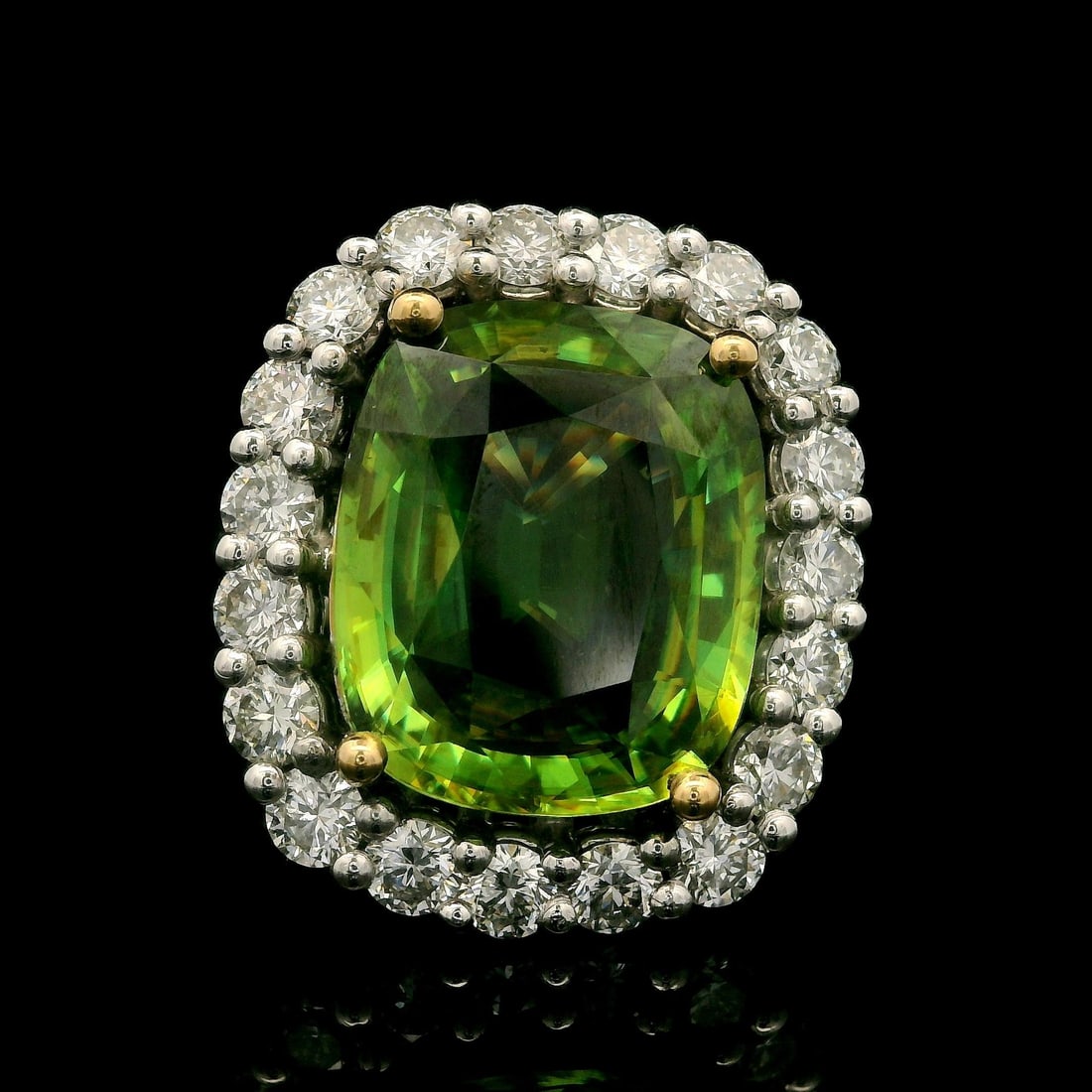 18k Gold GIA 10.46ctw Cushion Sphene & Diamond Halo Ring: 18k Gold GIA 10.46ctw Cushion Sphene & Diamond Halo Ring This stunning cocktail ring features a captivating cushion-cut sphene, nestled within a dazzling halo of diamonds. The main stone, a natural ge