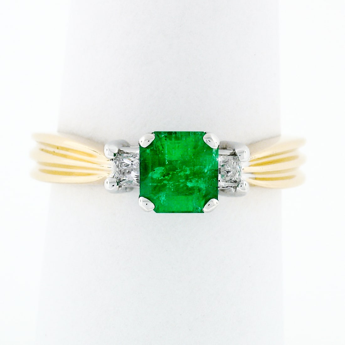 14k Gold 1.08ct Three Stone Emerald Diamond Accent Ring: 14k Gold 1.08ct Three Stone Emerald Diamond Accent Ring This exquisite three-stone ring showcases a stunning natural emerald at its center, beautifully complemented by two princess-cut diamond accents