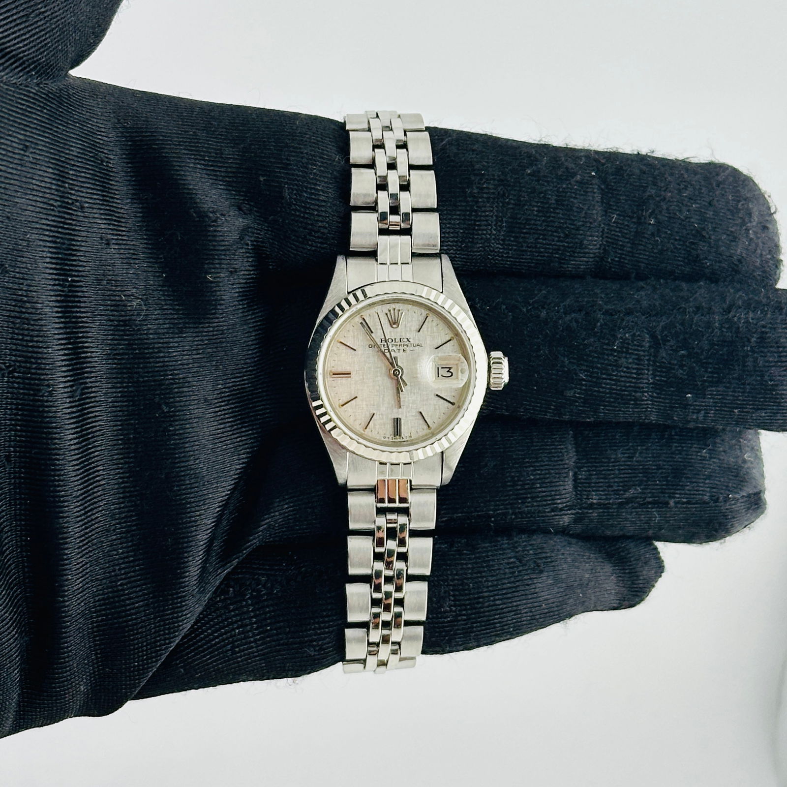 Ladies Oyster Perpetual Date Watch Silver Linen Dial Ref 6917 Jubilee Bracelet: Ladies Oyster Perpetual Date Watch Silver Linen Dial Ref 6917 Jubilee Bracelet This is a ladies' Rolex Oyster Perpetual Date watch, reference 6917. It features a silver linen dial, a fluted bezel, and