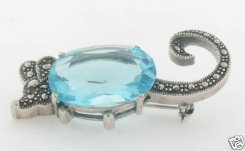 Unique Marcasite Sterling Silver Mouse Brooch with Blue Topaz: Unique Marcasite Sterling Silver Mouse Brooch with Blue Topaz This stunning Marcasite and Sterling Silver Mouse Brooch is an exquisite piece that showcases an intricate design. The brooch features a b