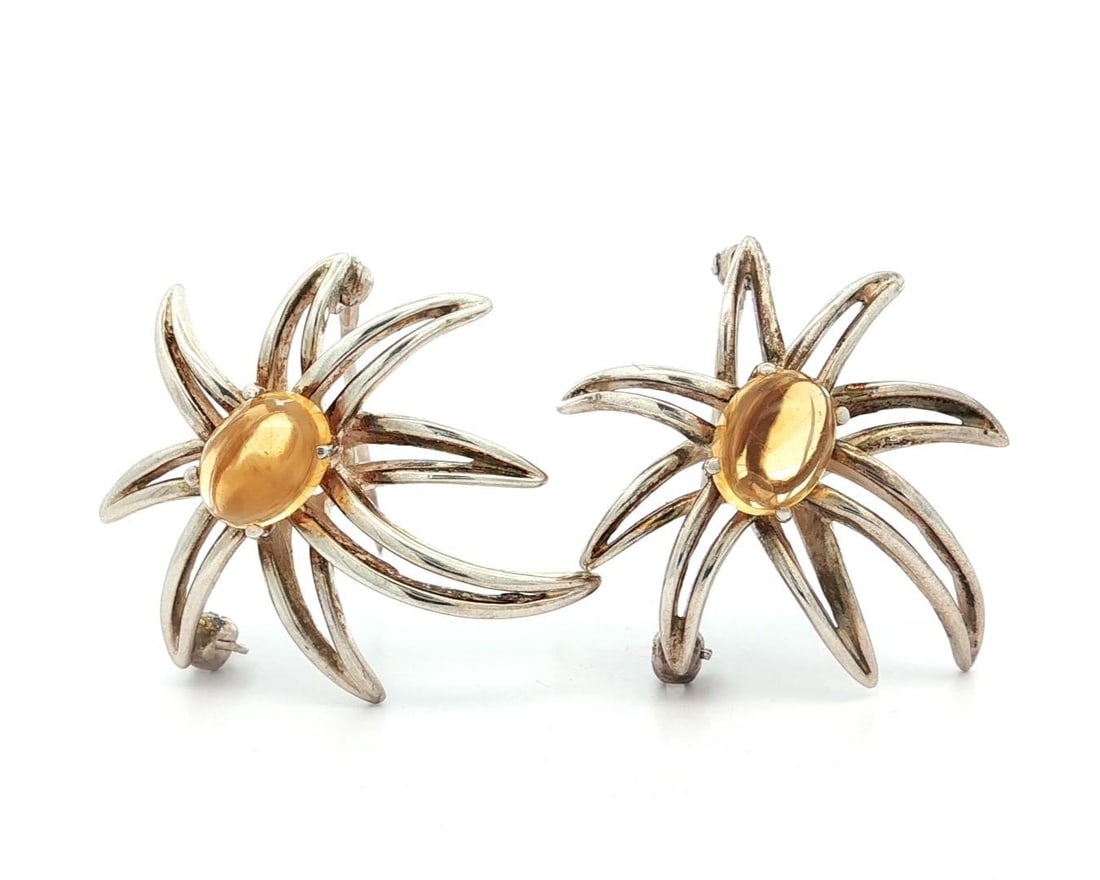Tiffany & Co. Sterling Silver Fireworks Brooch with Citrine Pair: Tiffany & Co. Sterling Silver Fireworks Brooch with Citrine Pair This exquisite pair of brooches from Tiffany & Co. features two natural genuine citrines, each cut in an oval cabochon shape. The vibra