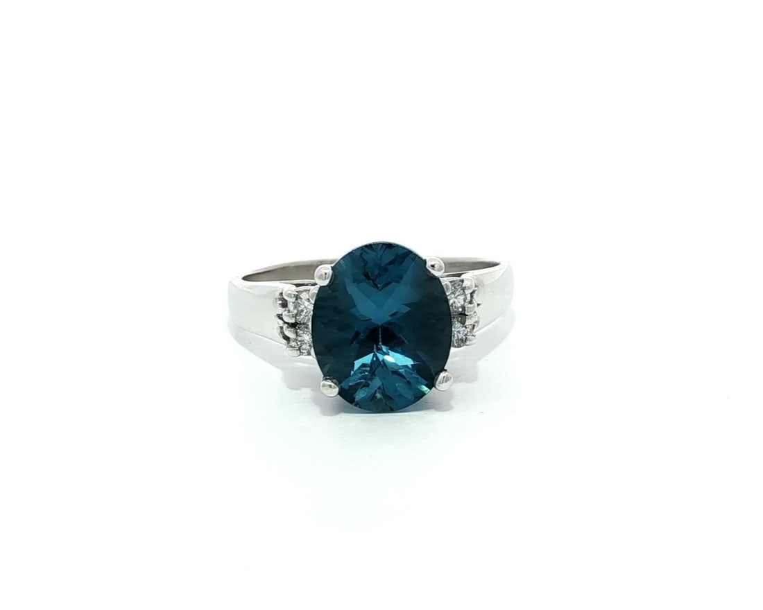 14k White Gold Oval London Blue Topaz Ring with Diamond Accents: 14k White Gold Oval London Blue Topaz Ring with Diamond Accents This exquisite cocktail ring features a stunning natural London blue topaz in an oval checkerboard cut, measuring approximately 11x9.3mm
