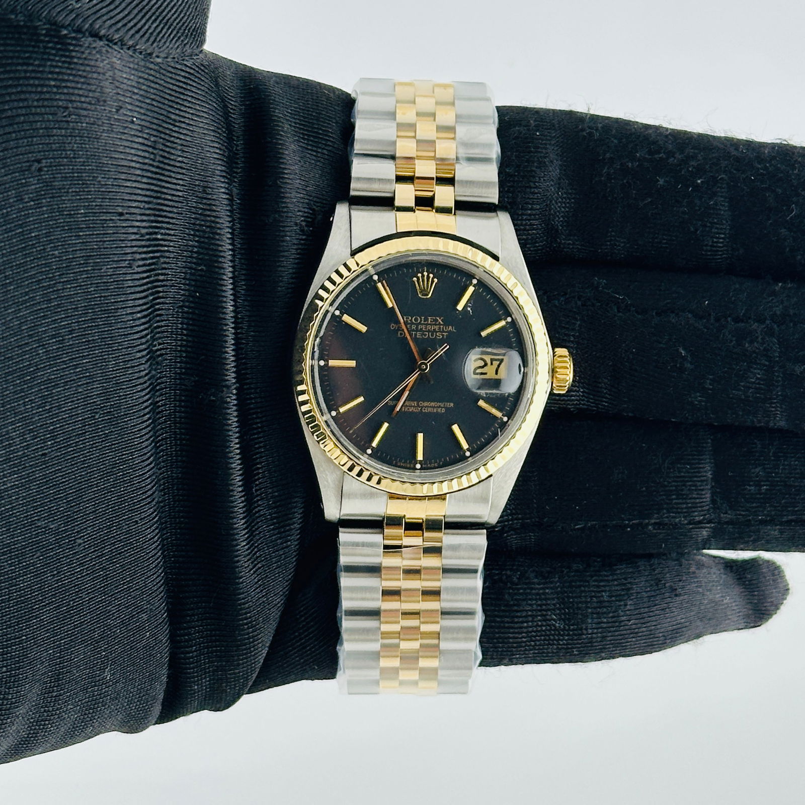 Datejust Ref 1601 Black Gold Stick Dial with Aftermarket Jubilee Bracelet: Datejust Ref 1601 Black Gold Stick Dial with Aftermarket Jubilee Bracelet This Rolex Datejust features a black and gold stick dial, complemented by a fluted bezel and an aftermarket Jubilee bracelet.
