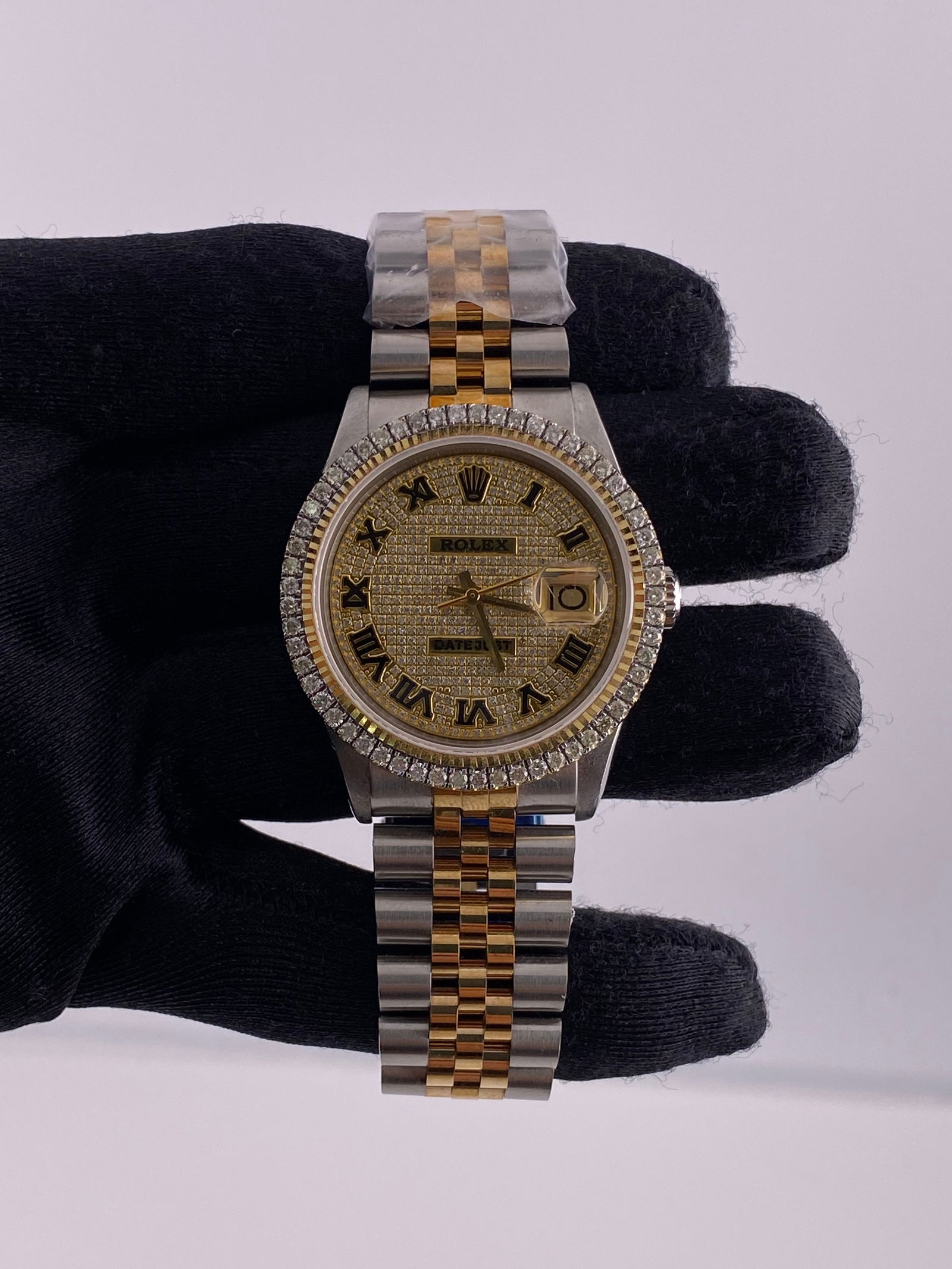 Prong Bezel Iced Roman Dial Rolex 1601 with Aftermarket Jubilee Bracelet: Prong Bezel Iced Roman Dial Rolex 1601 with Aftermarket Jubilee Bracelet This Rolex Datejust watch features an Iced Out Roman dial and a prong plated bezel. It is equipped with an Aftermarket Jubilee